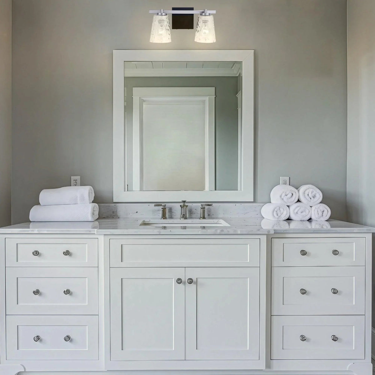 2-light vanity light with clear glass shades and black bar mounting plate.