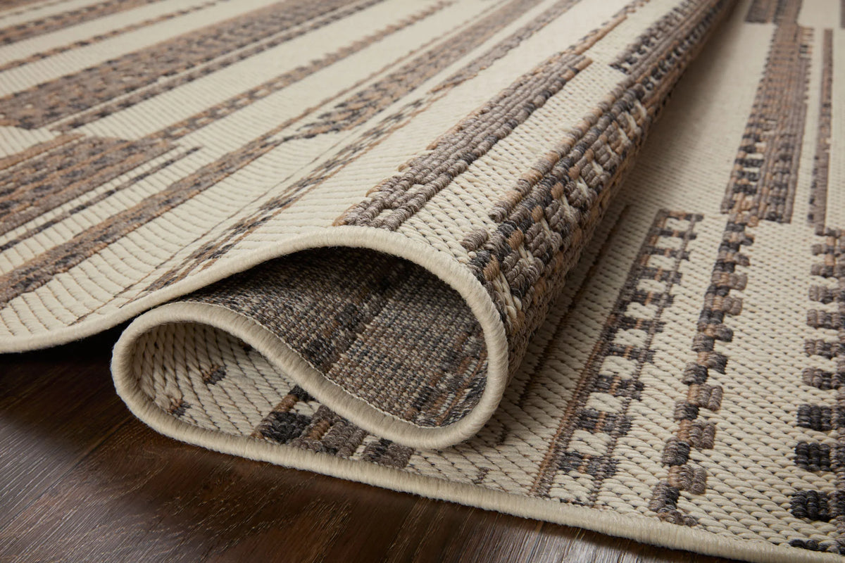 Ivory and taupe area rug corner with folded texture and geometric woven stripe design