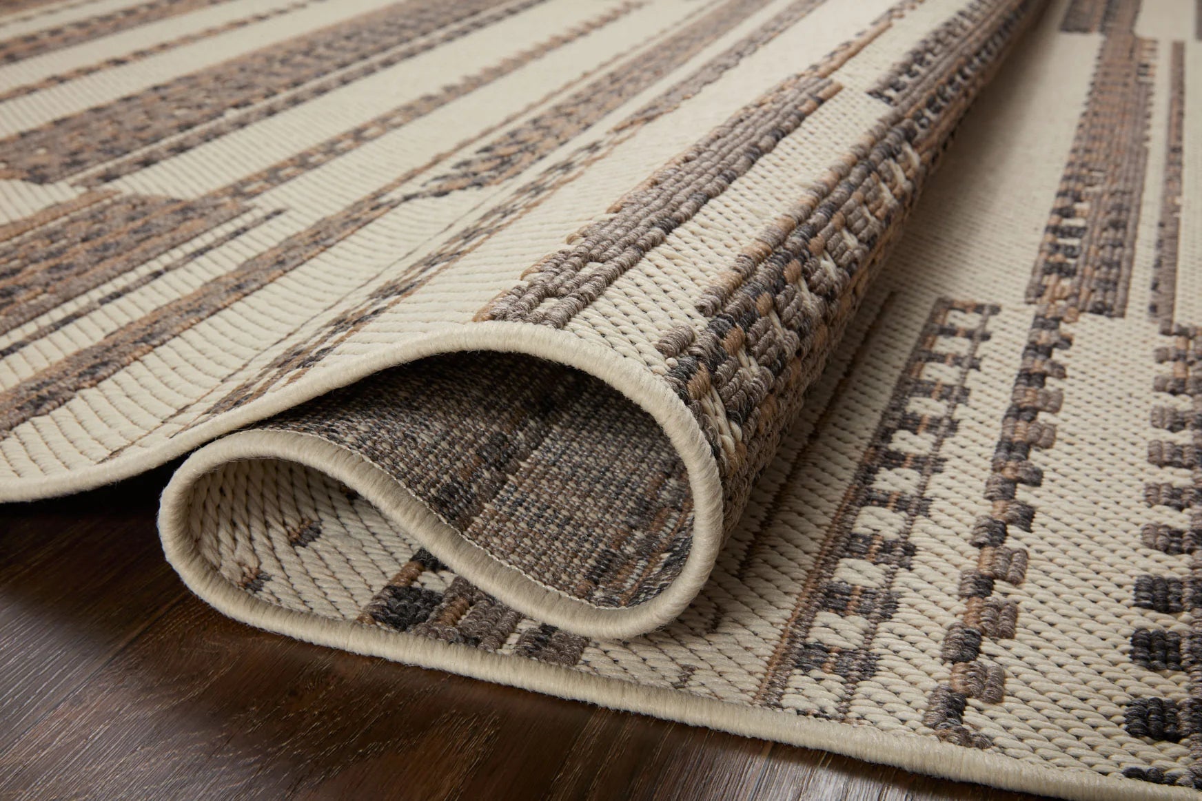 Ivory and taupe woven accent rug corner detail with short pile and textured underside