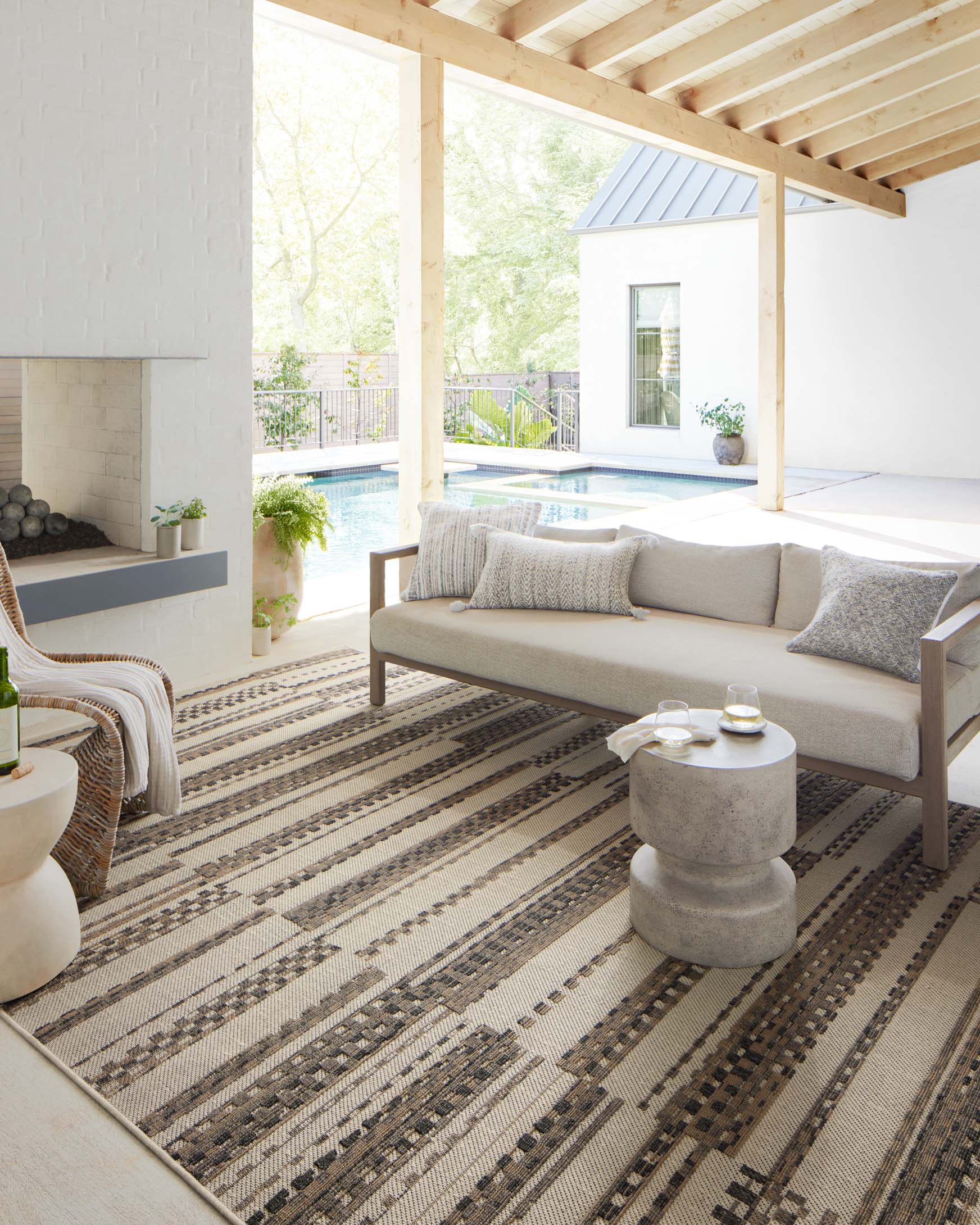 Ivory and taupe accent rug laid on floor with low-pile woven stripes and border trim