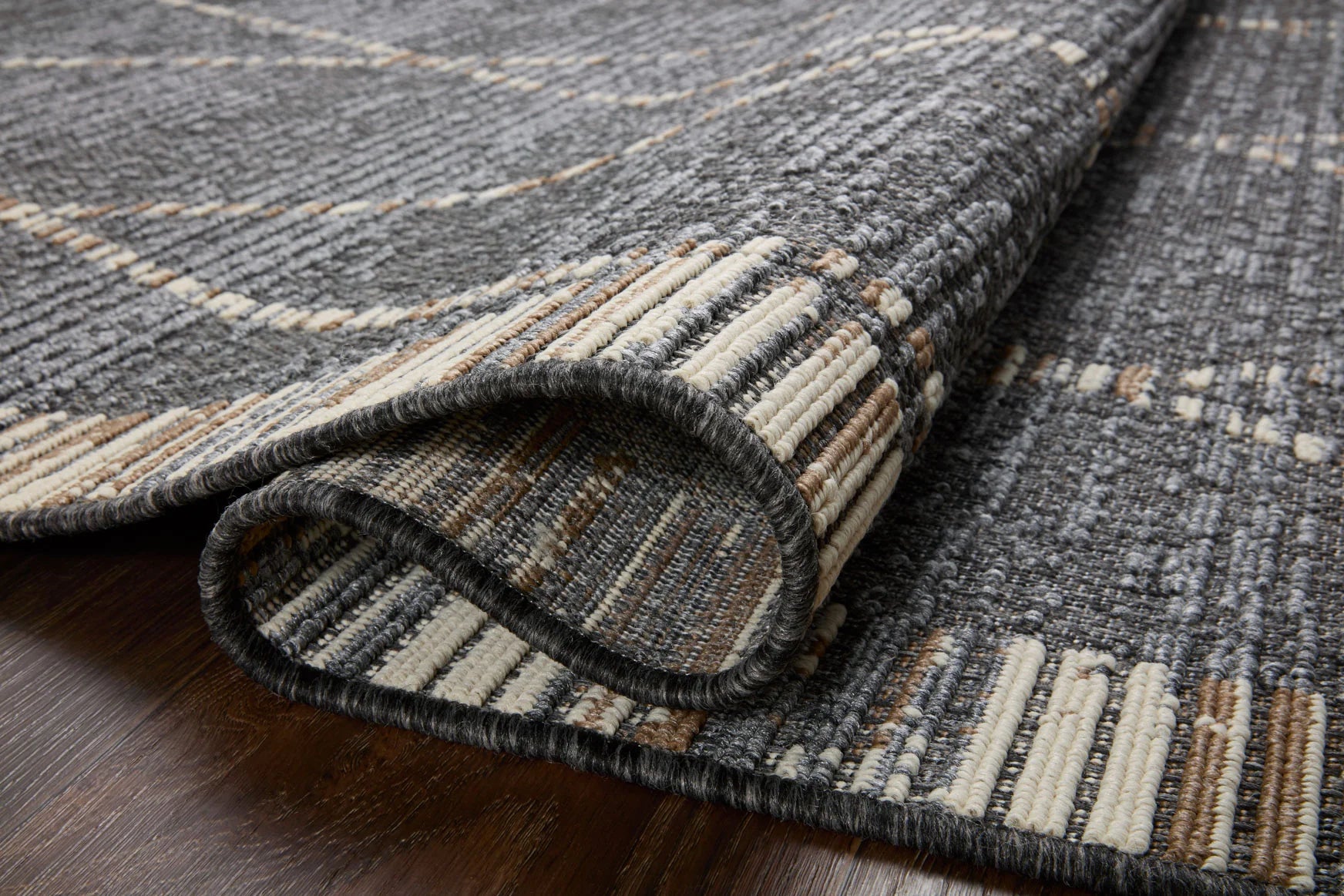 Slate gray rug corner with bound edge and striped detail