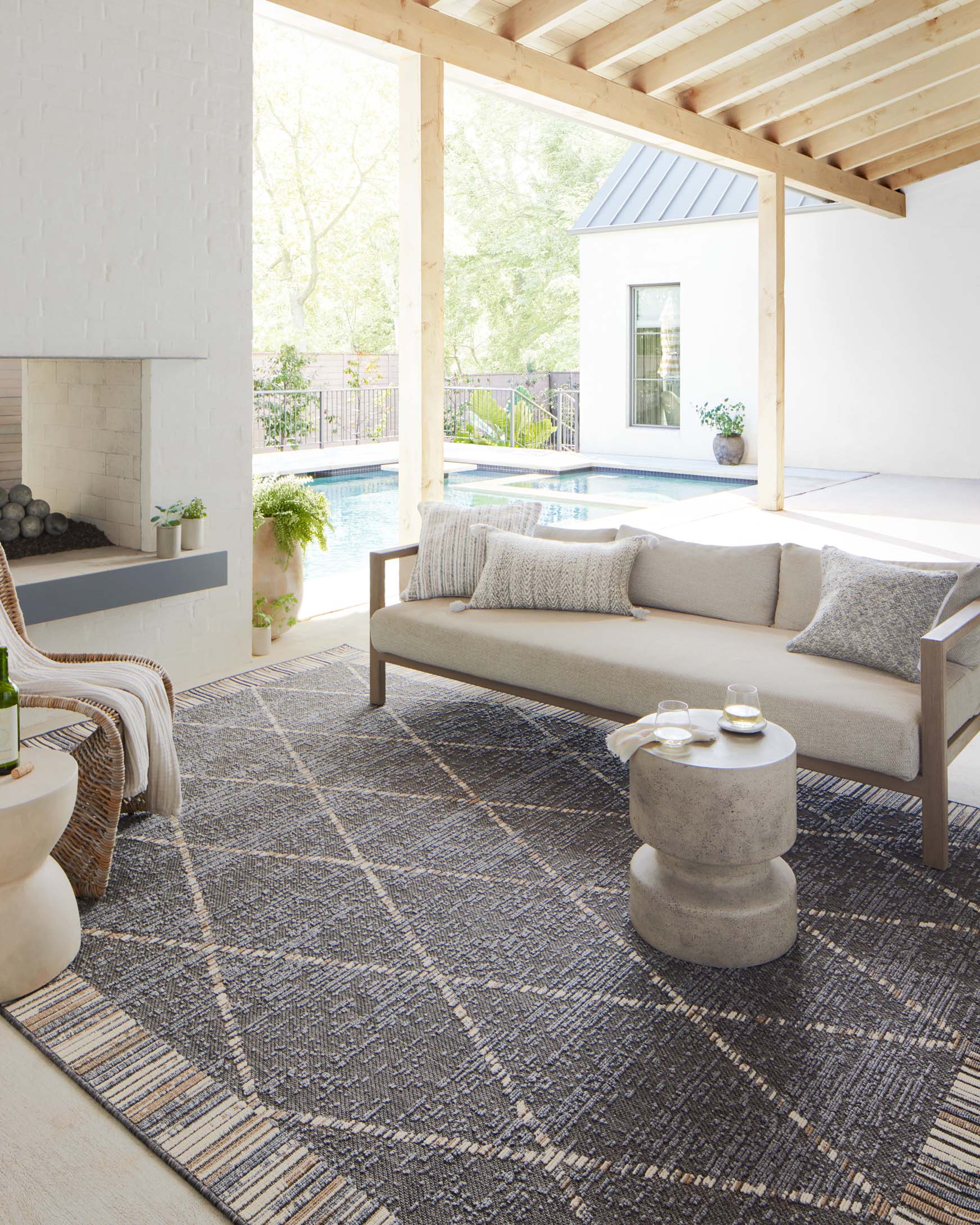 Slate gray geometric rug on floor with striped border