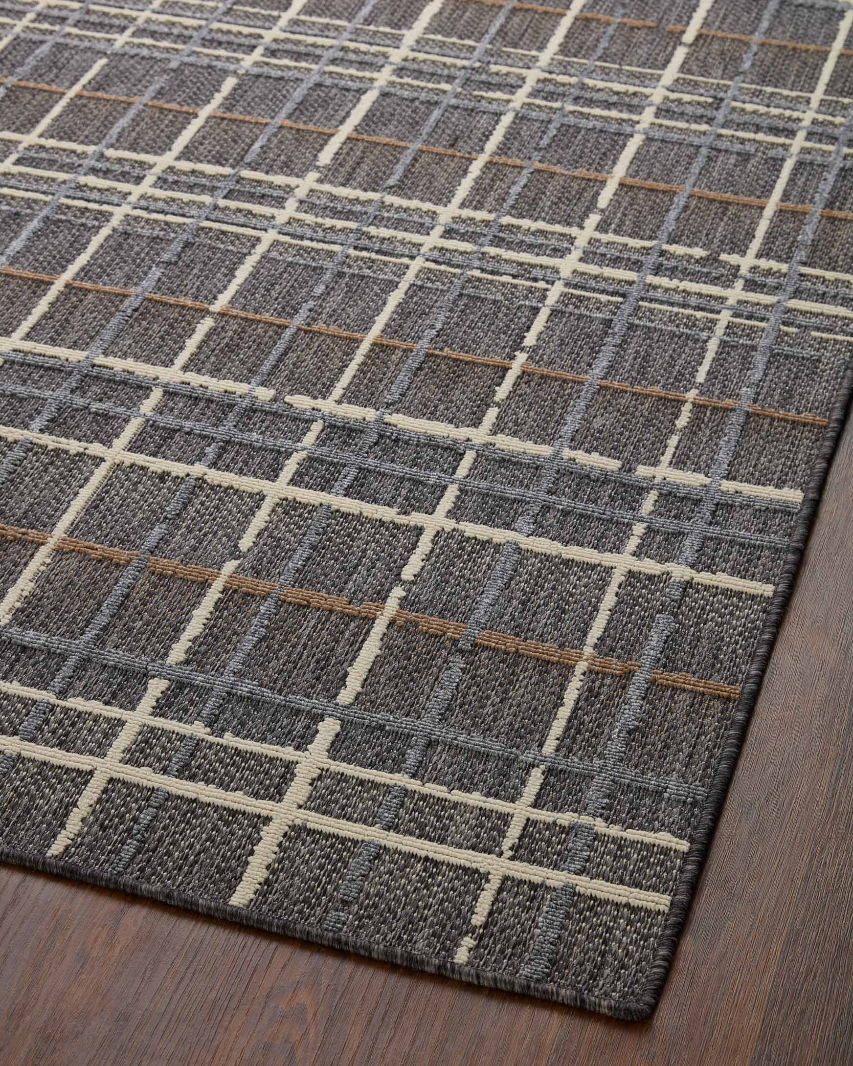 Charcoal indoor/outdoor accent rug showing cream grid lines and thin tan accents