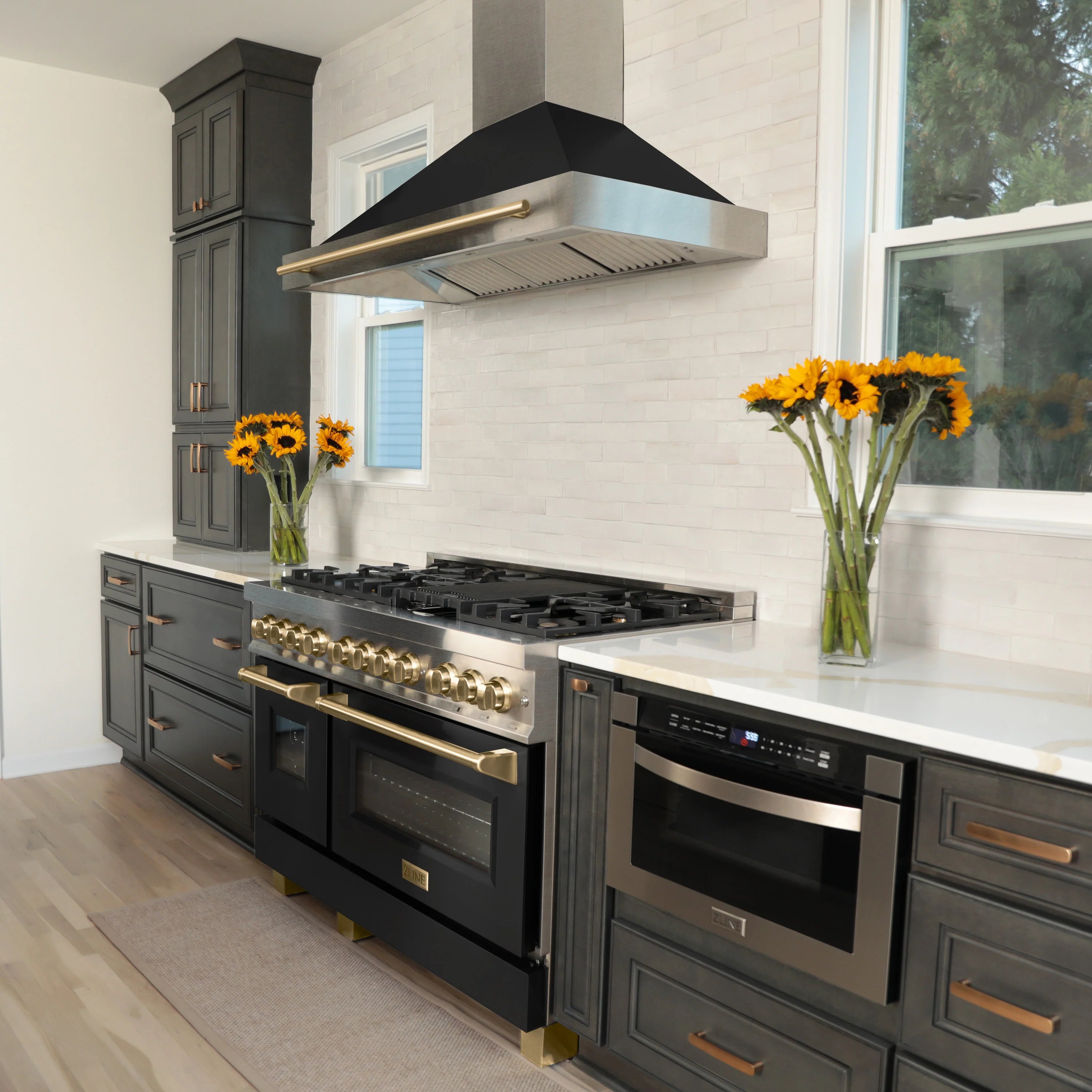 Stainless steel dual fuel range with black oven doors and gold handle accents