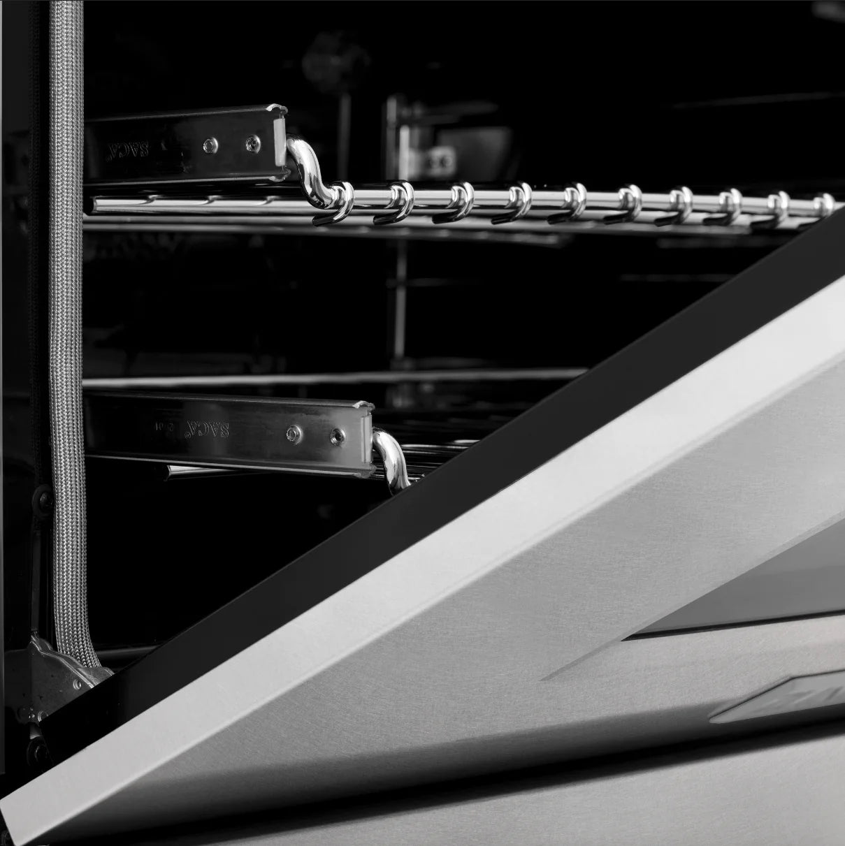 Dual fuel oven door hinge area with chrome handle bar detail