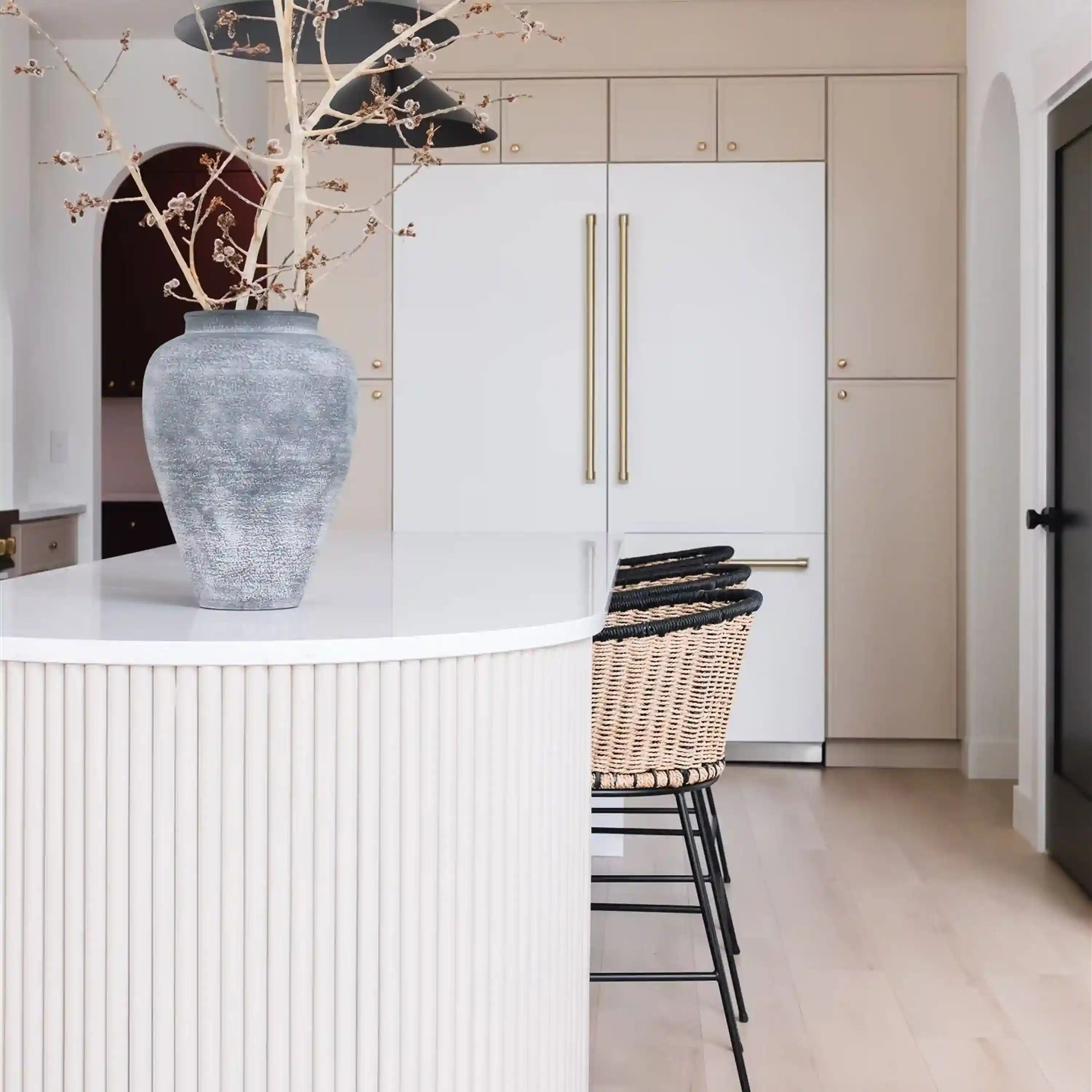 White matte French-door refrigerator with dual gold handles and open interior shelves