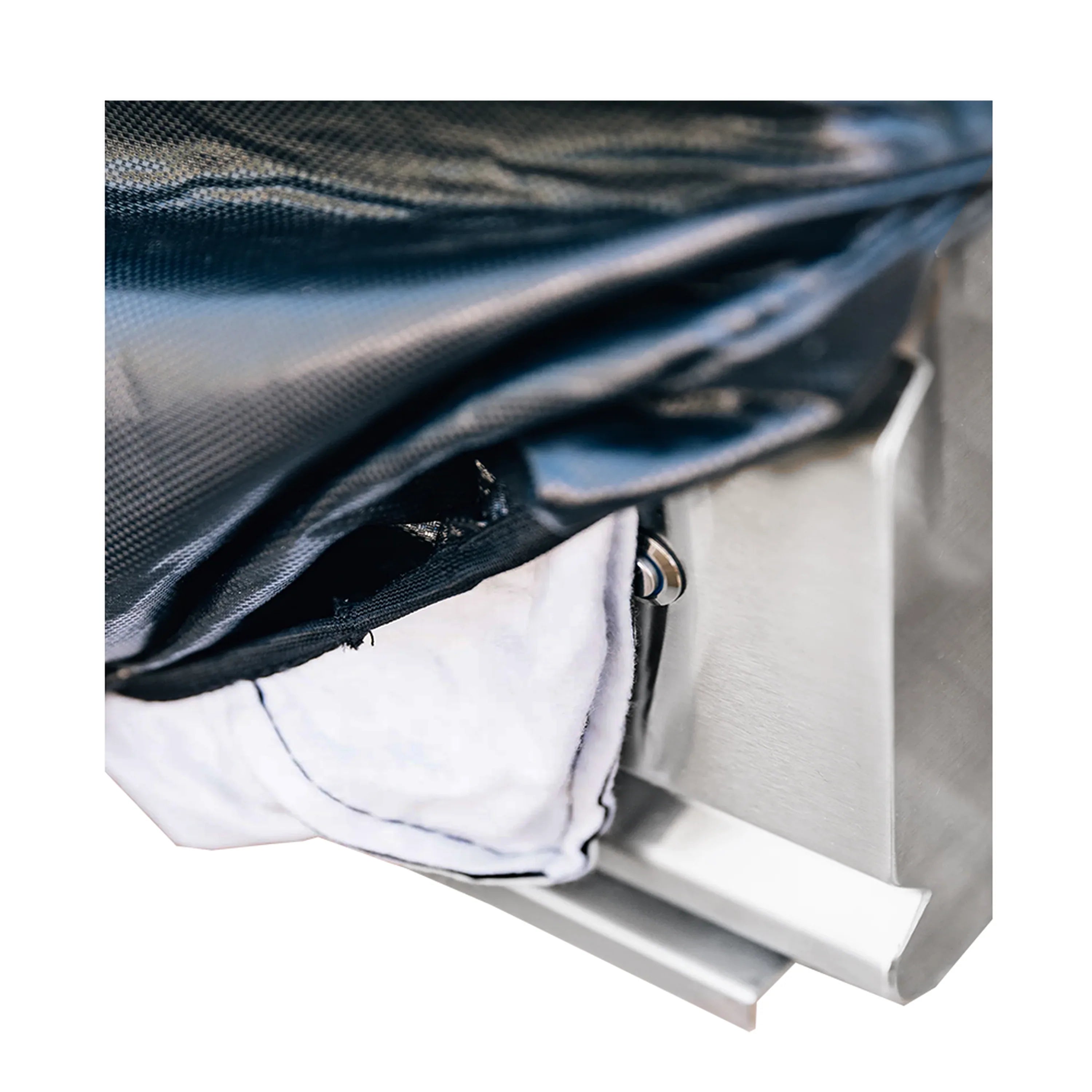Dark vinyl cover draped over built-in unit with exposed mounting edge