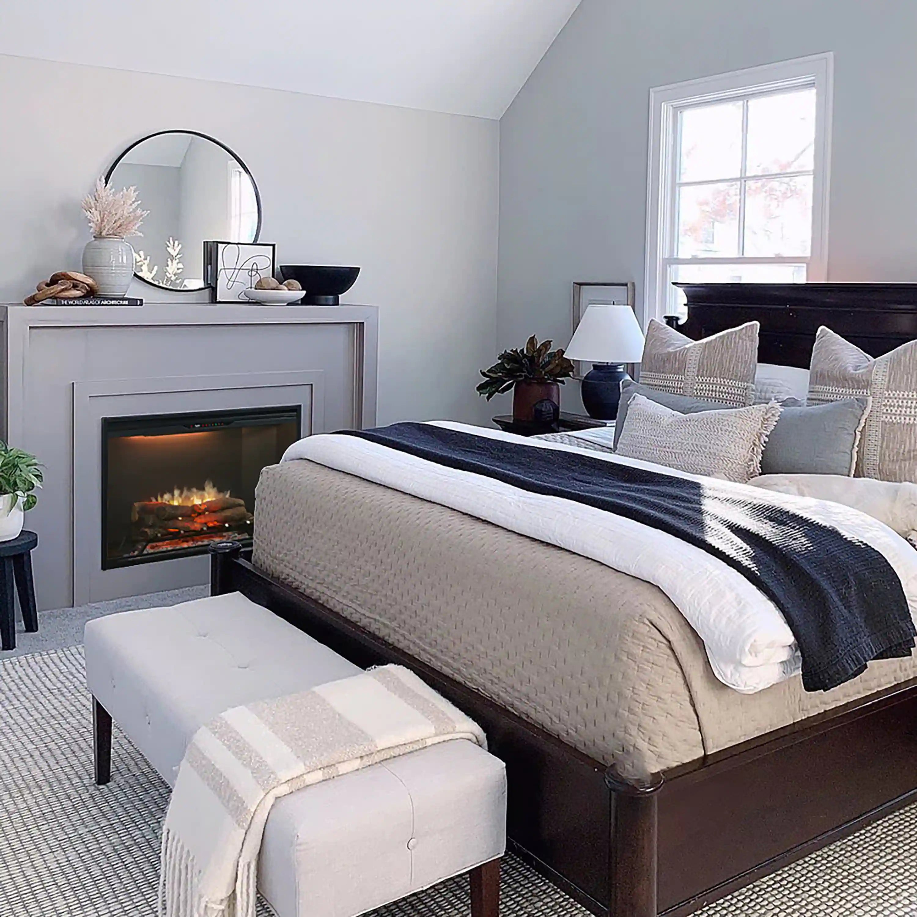 Built-in black electric fireplace insert with glowing flame inside a white mantel opening