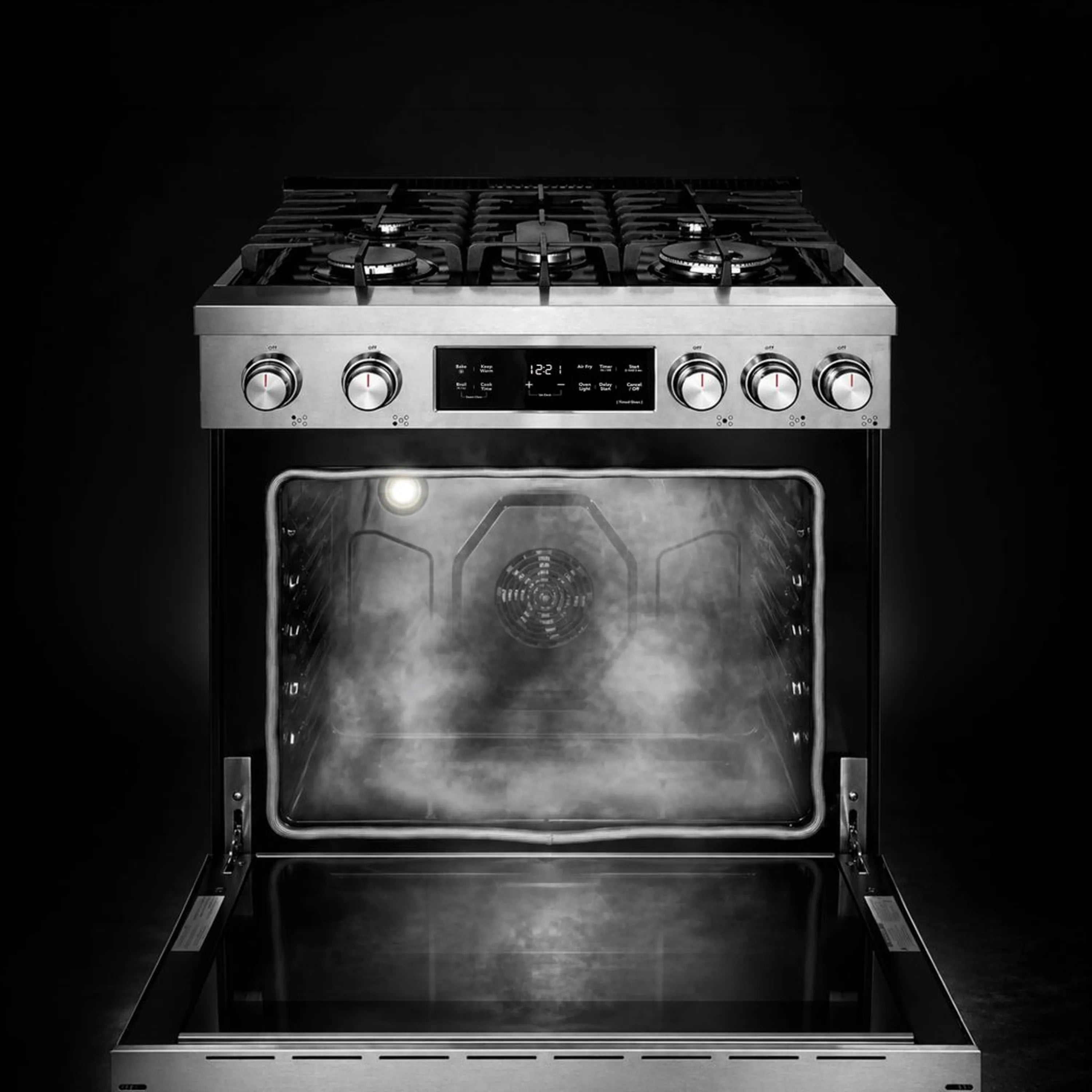 Stainless steel gas oven with burners above and illuminated cooking cavity