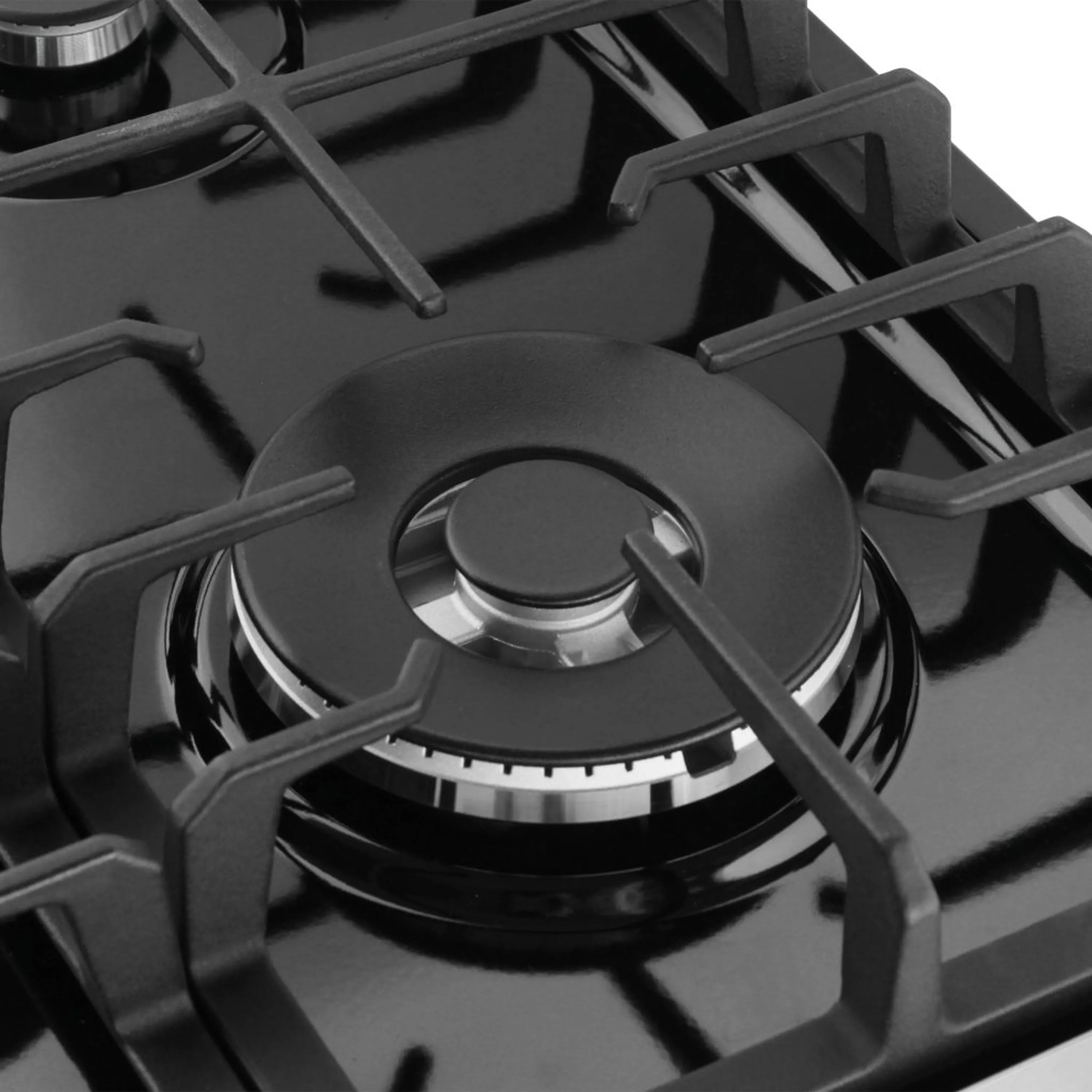 Close-up of black gas burner cap and cast-iron grates on the cooktop