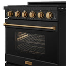 Black gas range with bronze control knobs and open oven door with wire rack