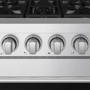 Close-up of stainless steel gas range control knobs with indicator markings