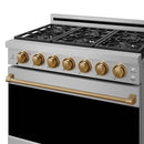 Stainless steel gas range cooktop with bronze trim rail and gold control knobs