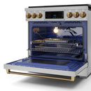 Open oven door of stainless steel gas range with lit interior and wire racks