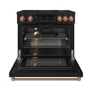 Black induction range with oven door open, racks inside, and rose gold trim; copper handle.