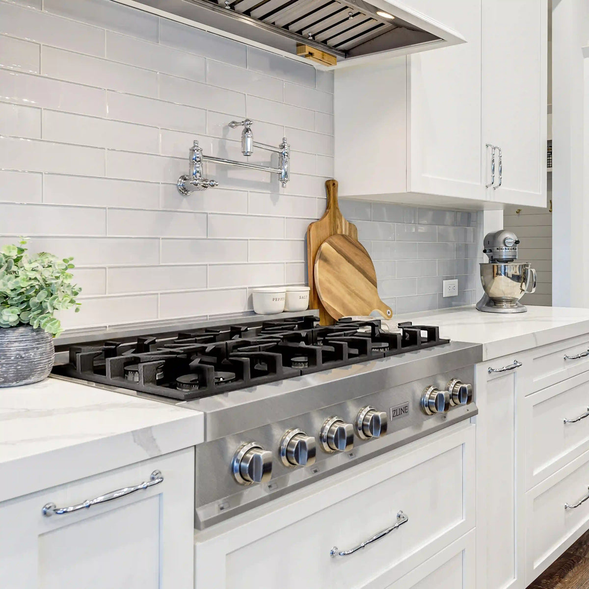 Stainless steel gas rangetop with burner grates and control knobs in a kitchen