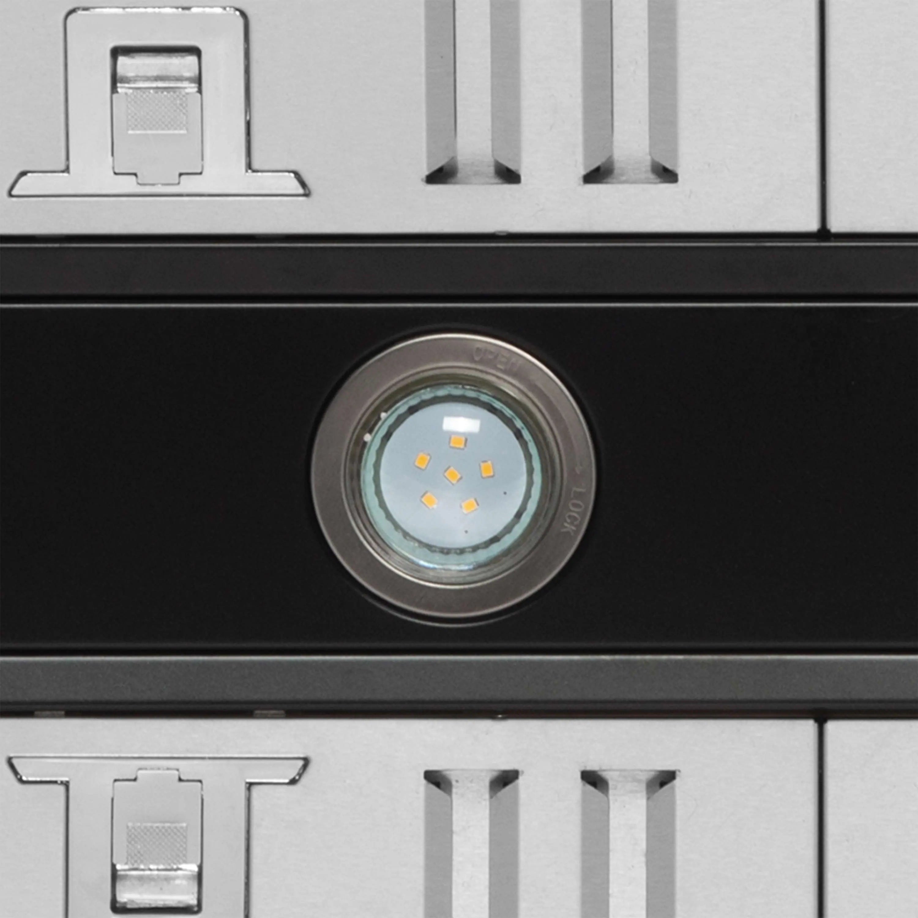 Range hood LED light lens centered on black panel above vent grille