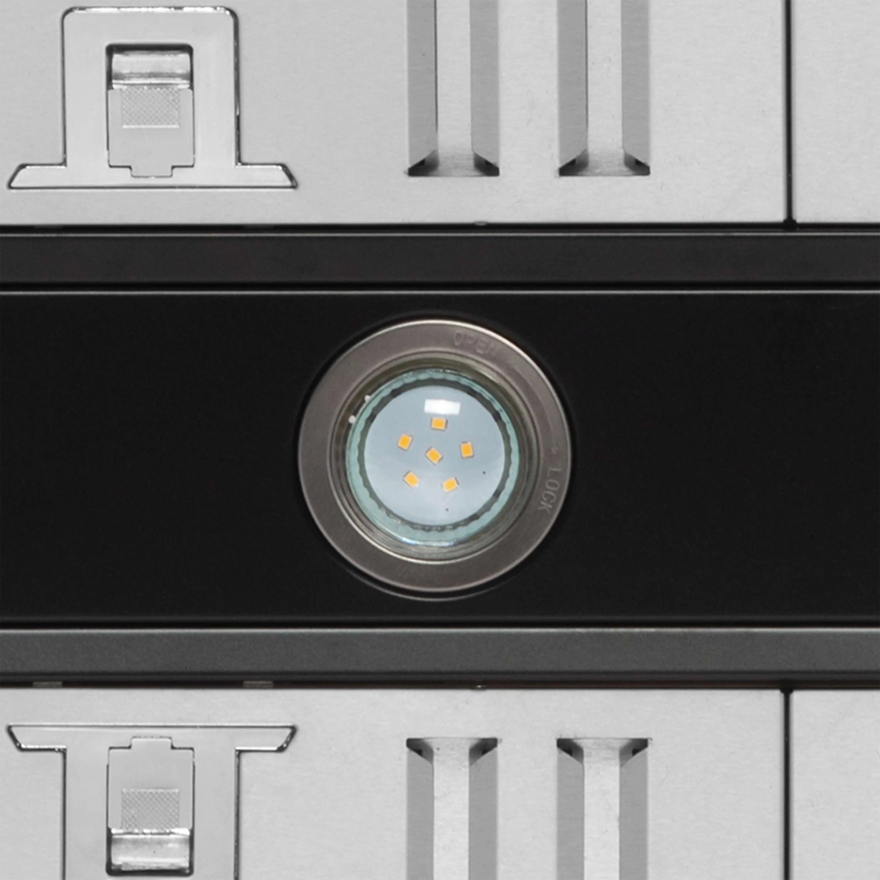 Black range hood front with circular LED light and metallic vent detail