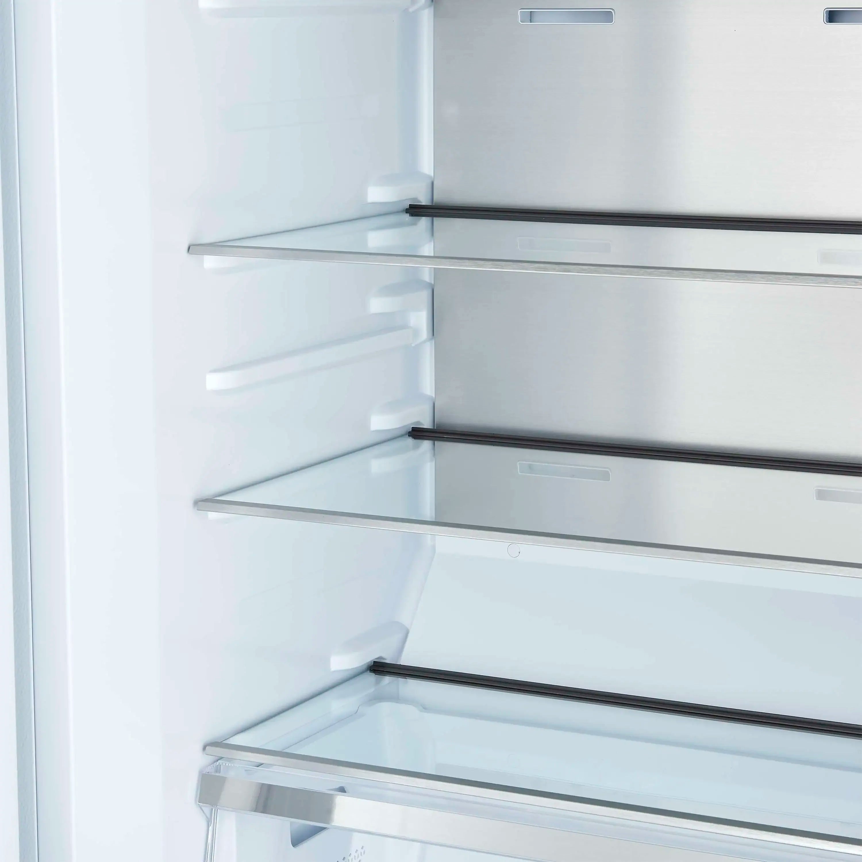 White refrigerator interior close-up with multiple glass shelves and side supports.