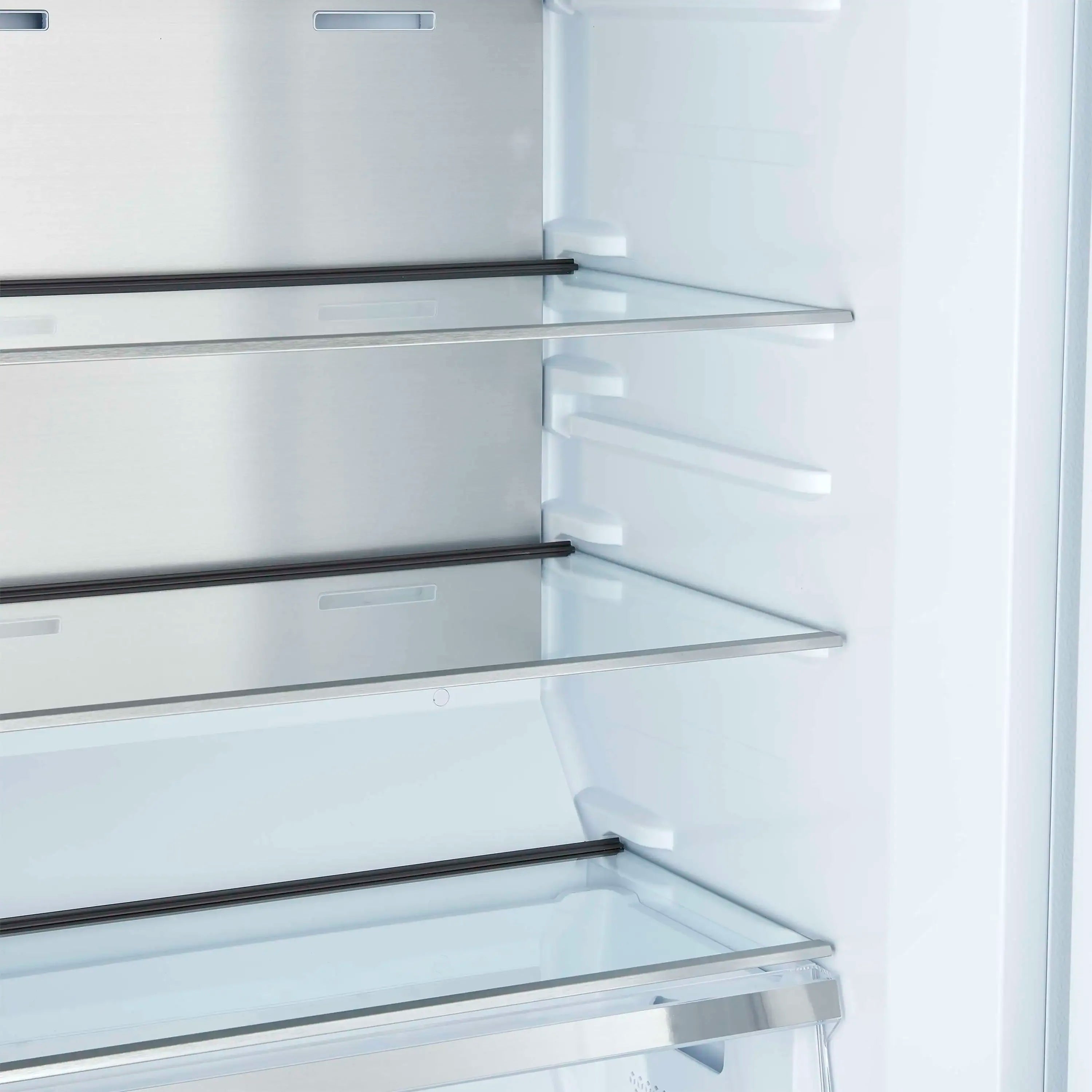 White refrigerator interior close-up with adjustable glass shelves and metal shelf trim.