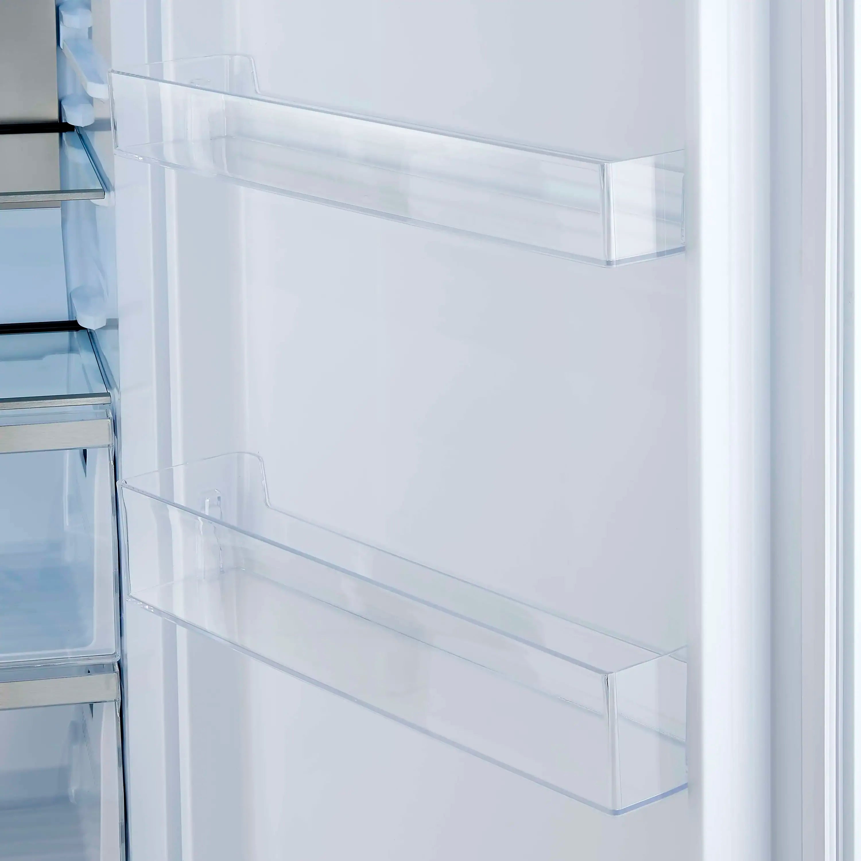 White refrigerator door close-up with clear storage bin and molded dividers.