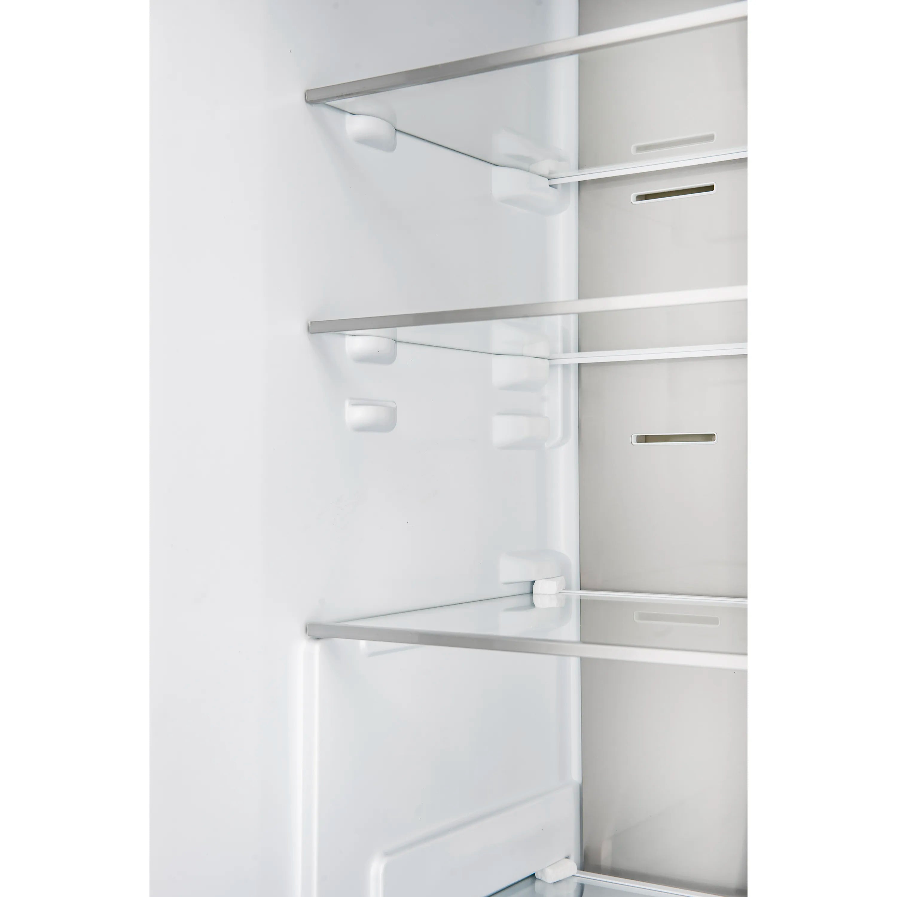 Bottom freezer refrigerator interior with white shelves, bins, and clear drawer rails.