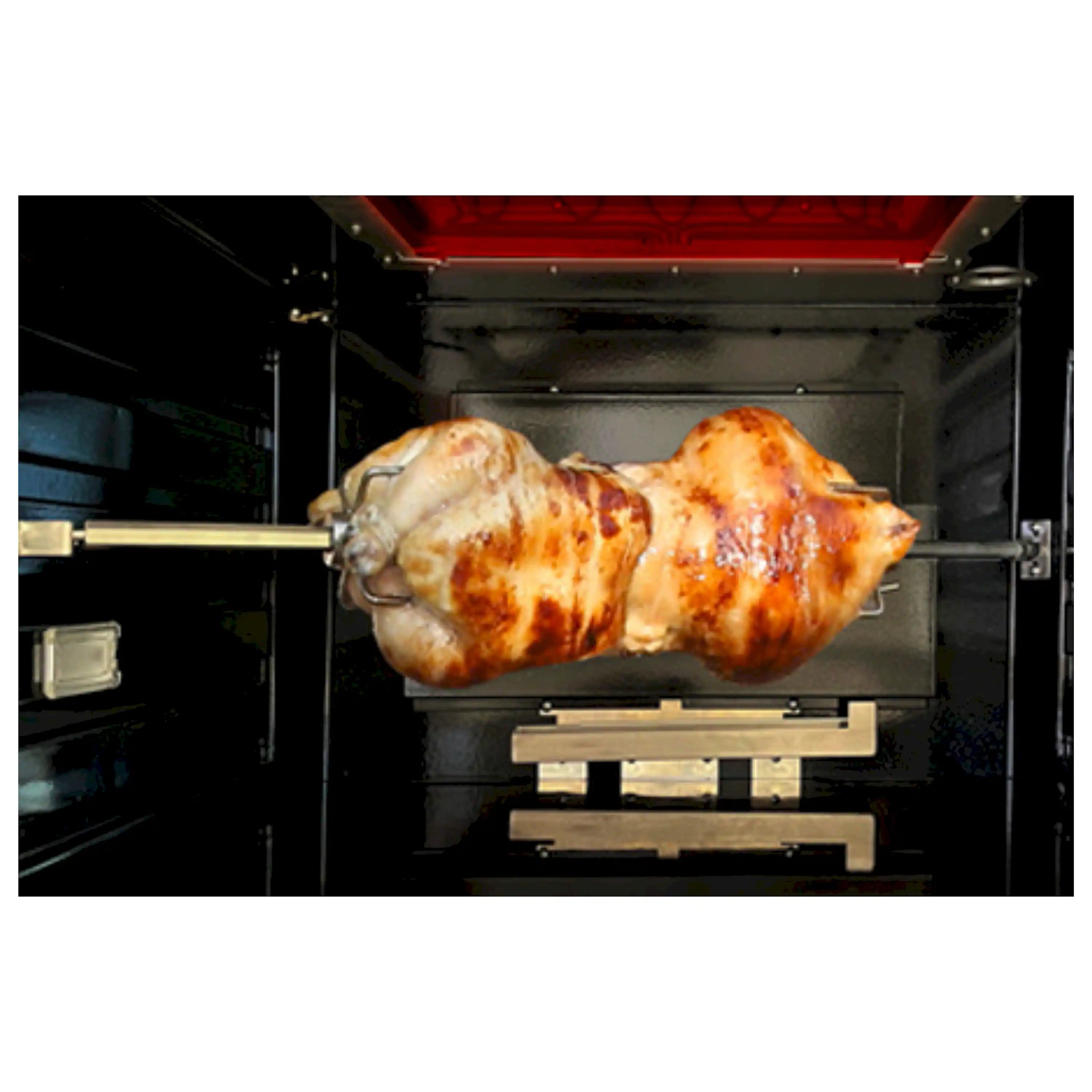 Stainless steel oven with rotisserie chicken on a spit rod inside range