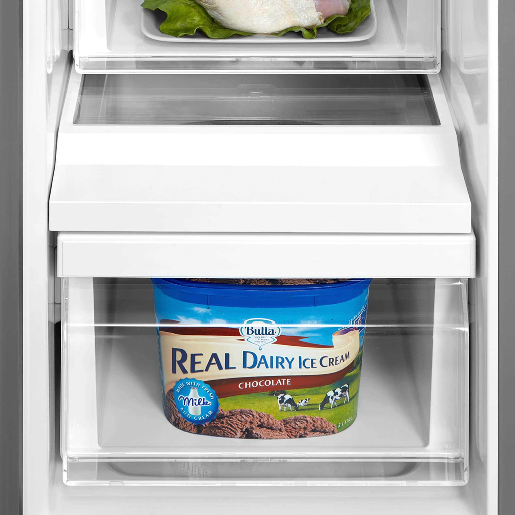 Refrigerator freezer drawer with ice cream container on a white shelf