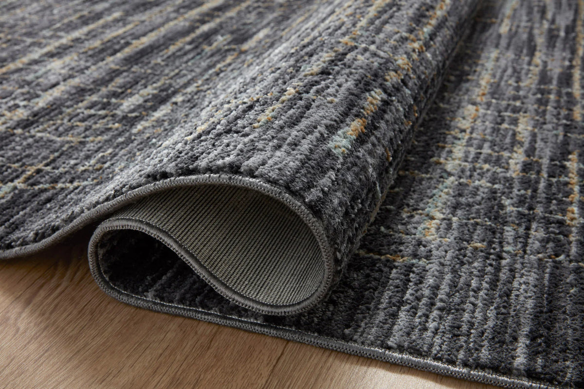 Close-up of charcoal rug edge with silver distressed pattern and bound border