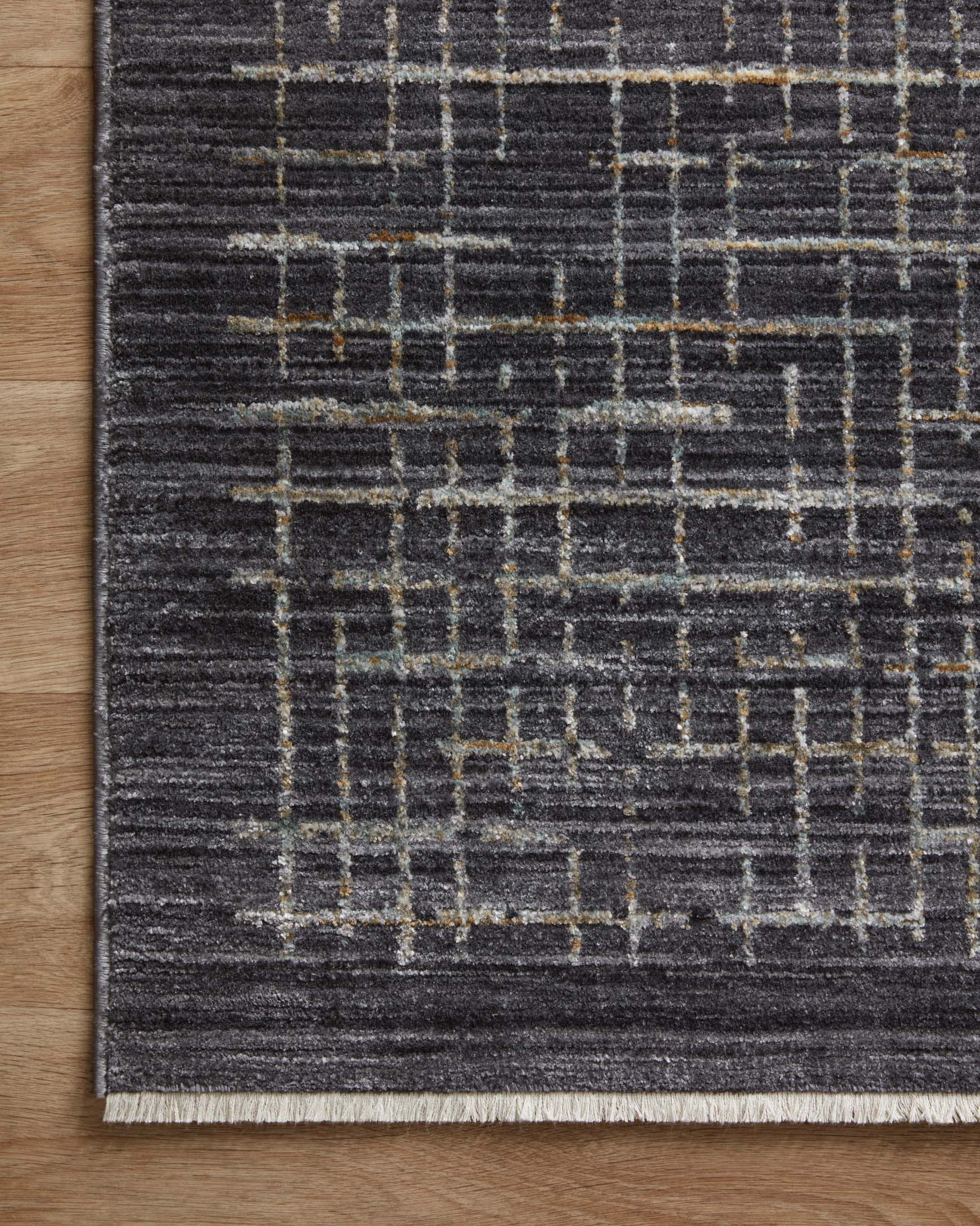 Corner view of dark runner rug with silver grid pattern and short fringe-free border