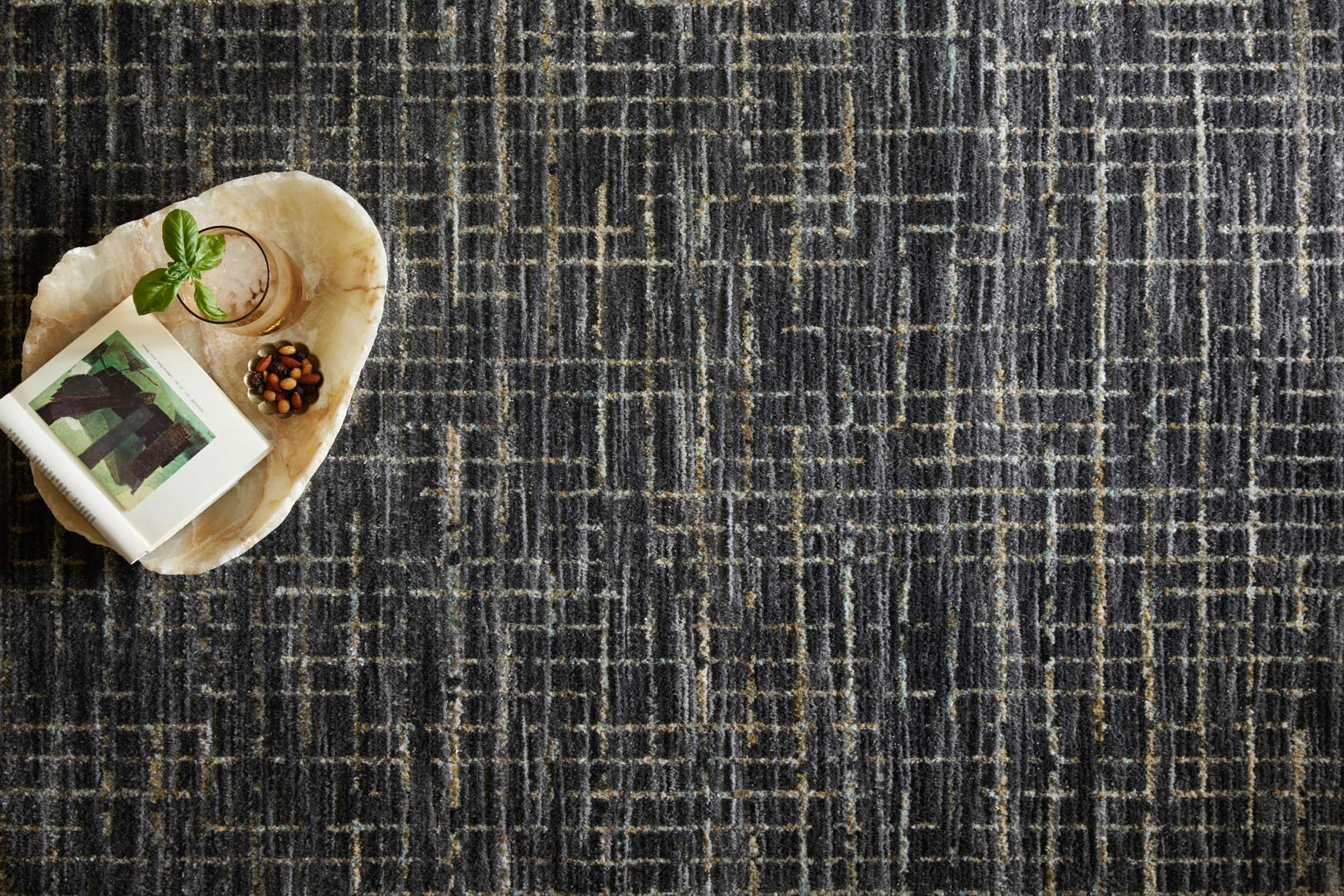 Close-up dark gray rug with silver and gold stitched grid lines