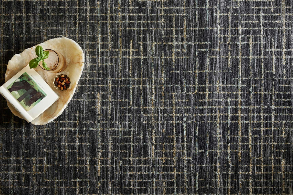 Dark charcoal rug surface with distressed grid pattern in silver and subtle gold