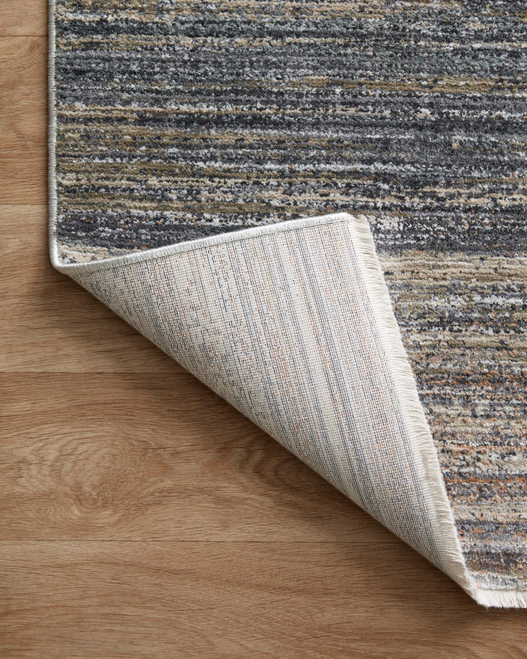 Runner rug showing low-pile construction and abstract striped pattern in gray and beige
