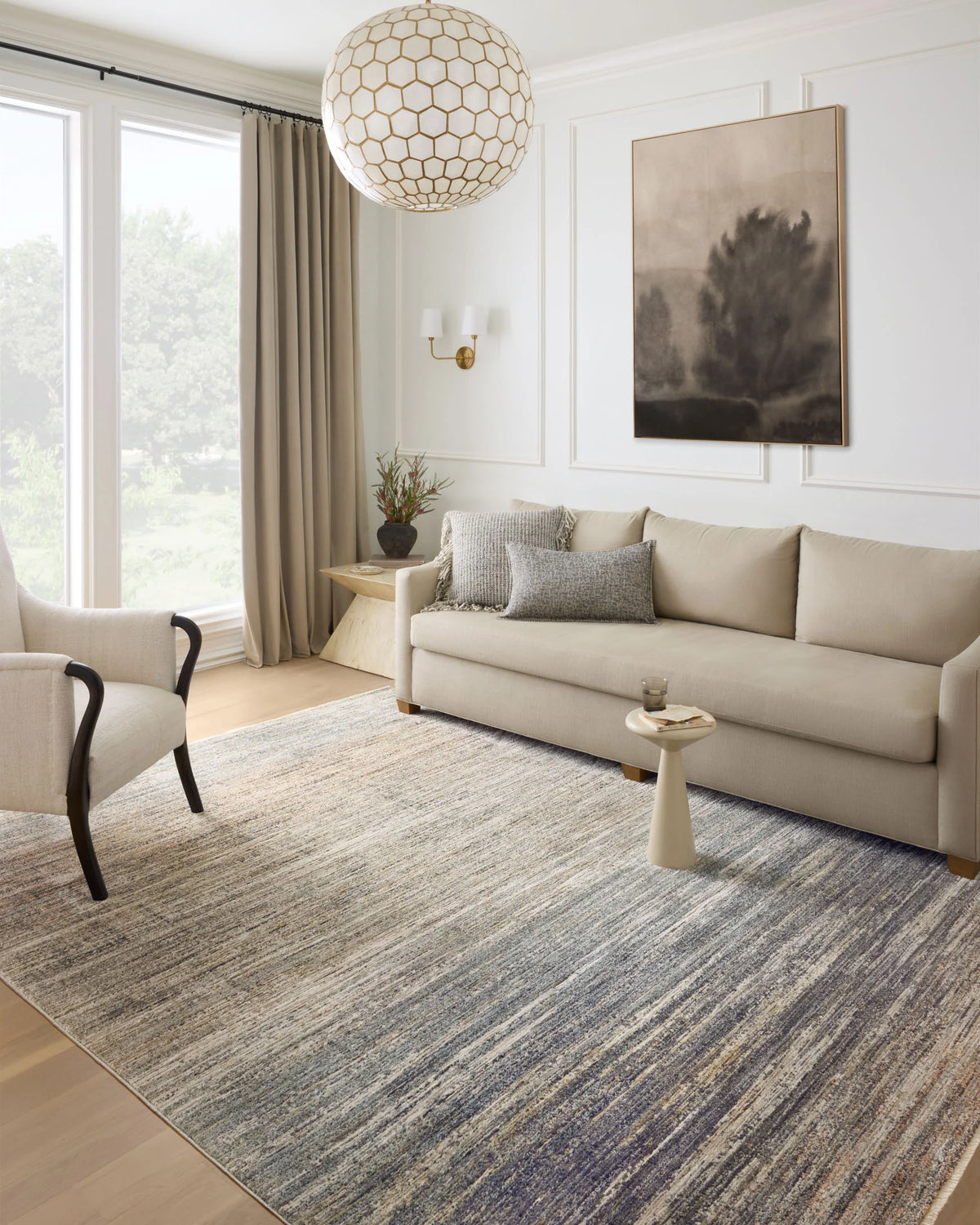 Runner rug in a living room setting, featuring abstract horizontal stripes in gray and beige