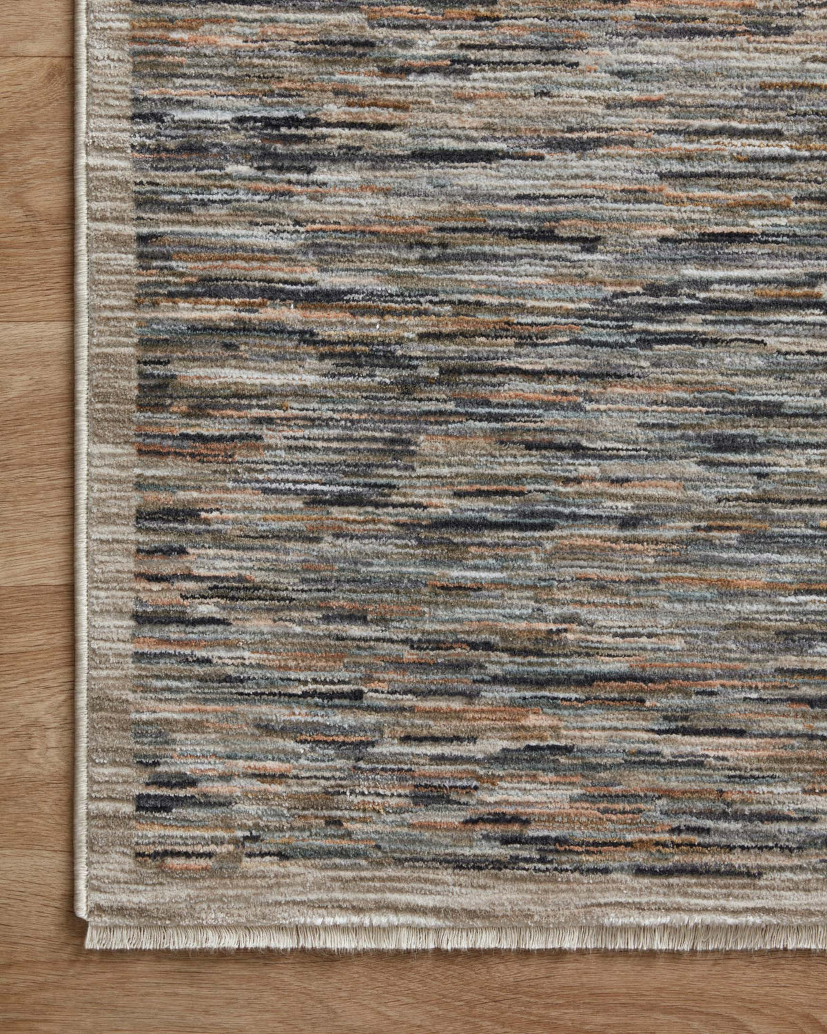 Corner view of blue-gray and tan horizontal striped area rug with fringed border.