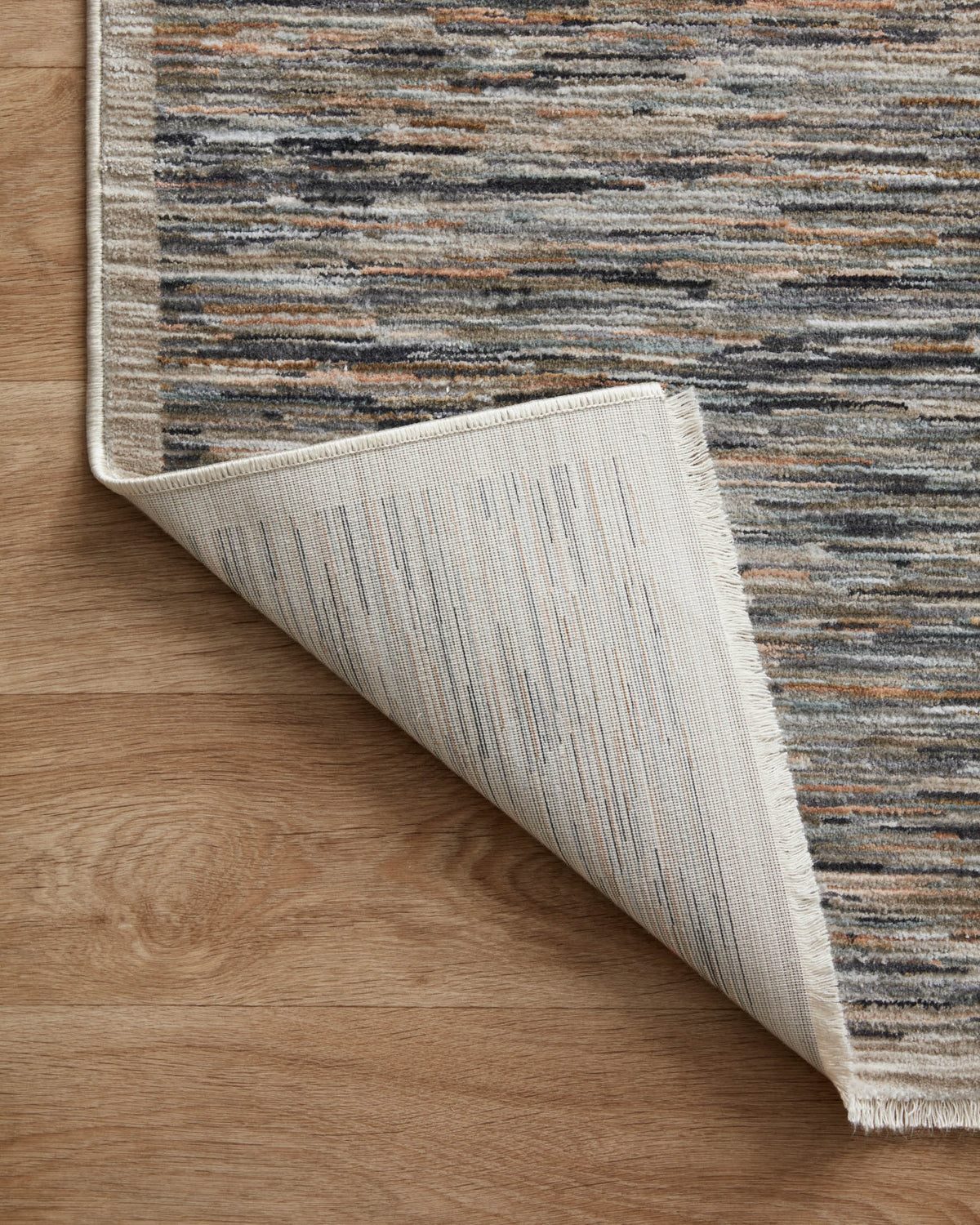Contemporary runner rug rolled view showing underside with ribbed texture and striped colors