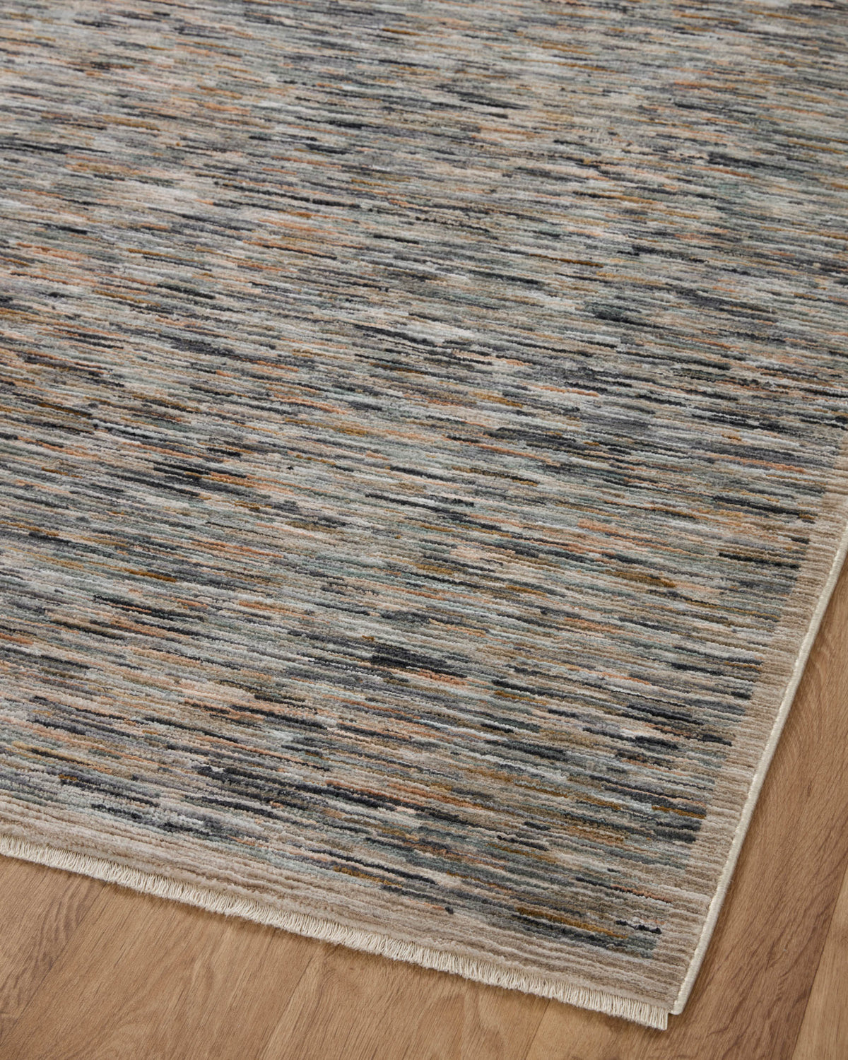 Runner rug close view of blue-gray, tan, and orange linear pattern with short fringe