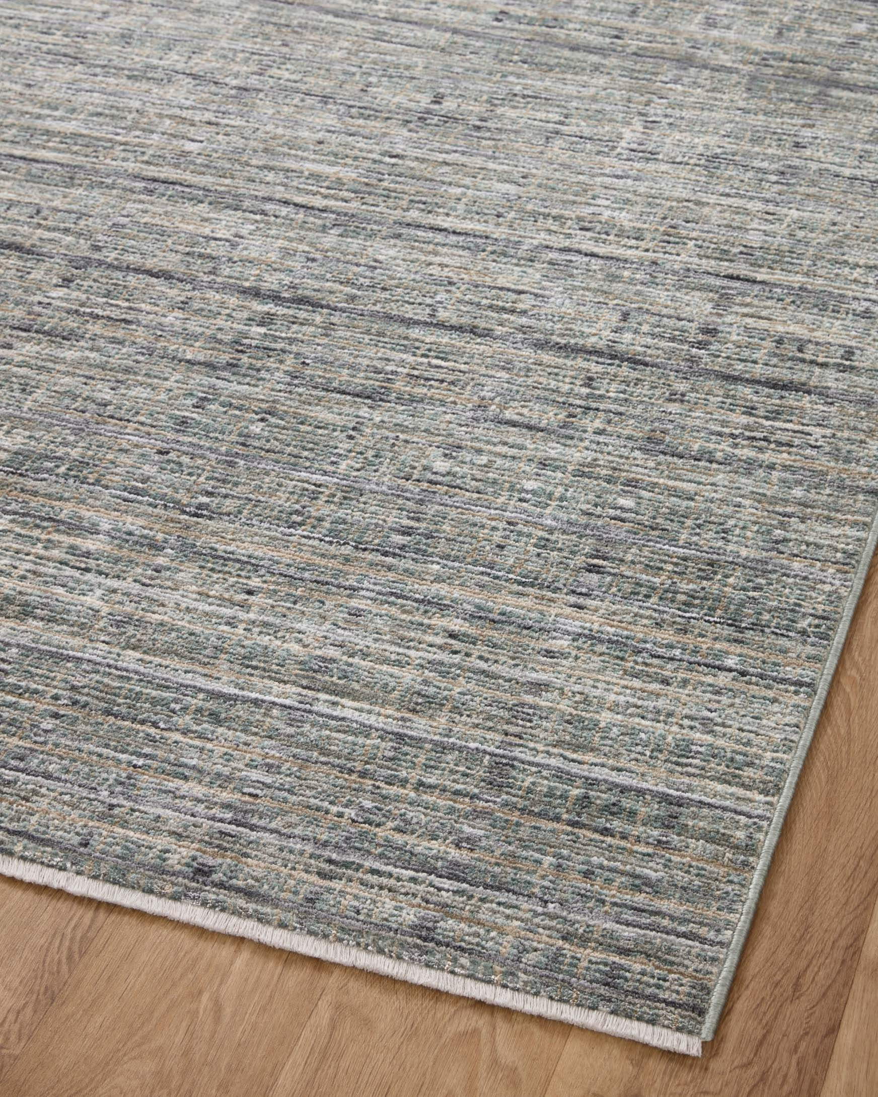 Flat area rug with low, mottled stripe pattern in blue-gray and speckled neutrals