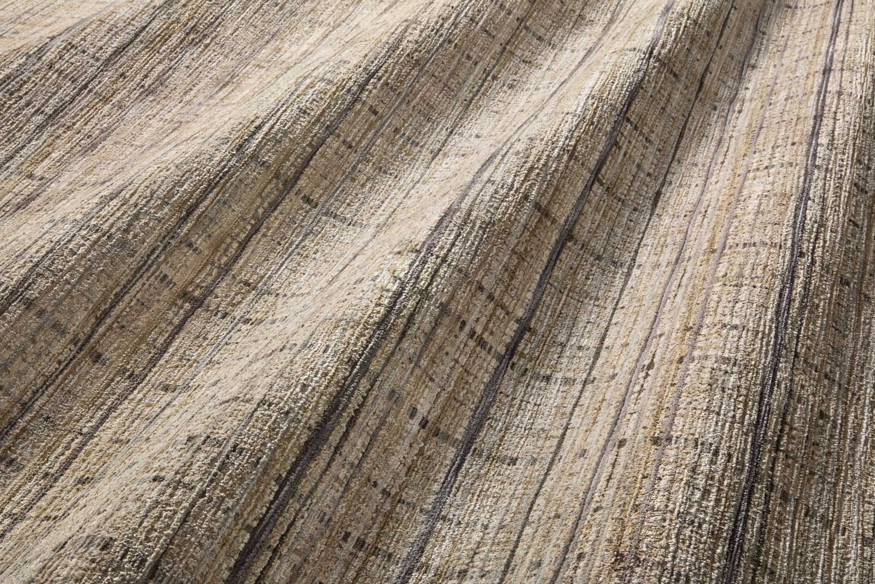 Close-up of beige rug surface with blue-gray and charcoal distressed line pattern.