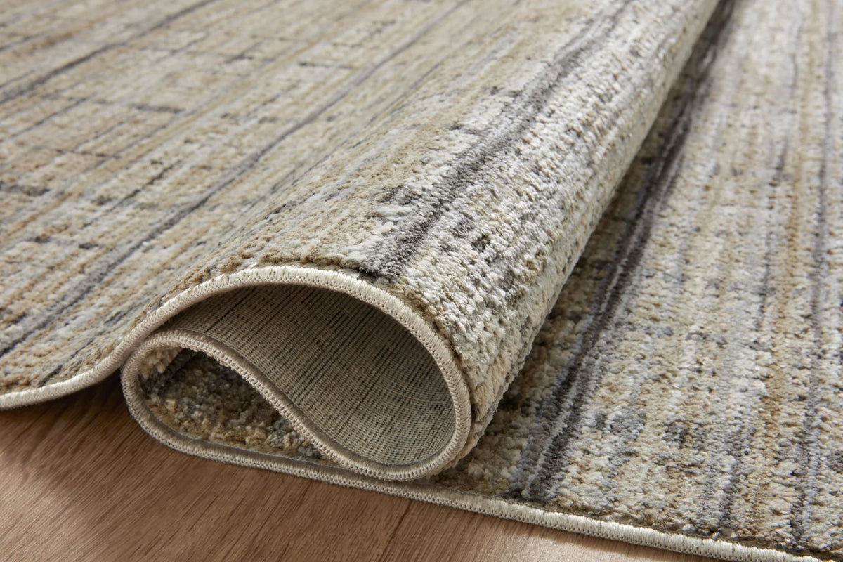 Rug edge close-up with folded border and beige top fabric over neutral underside