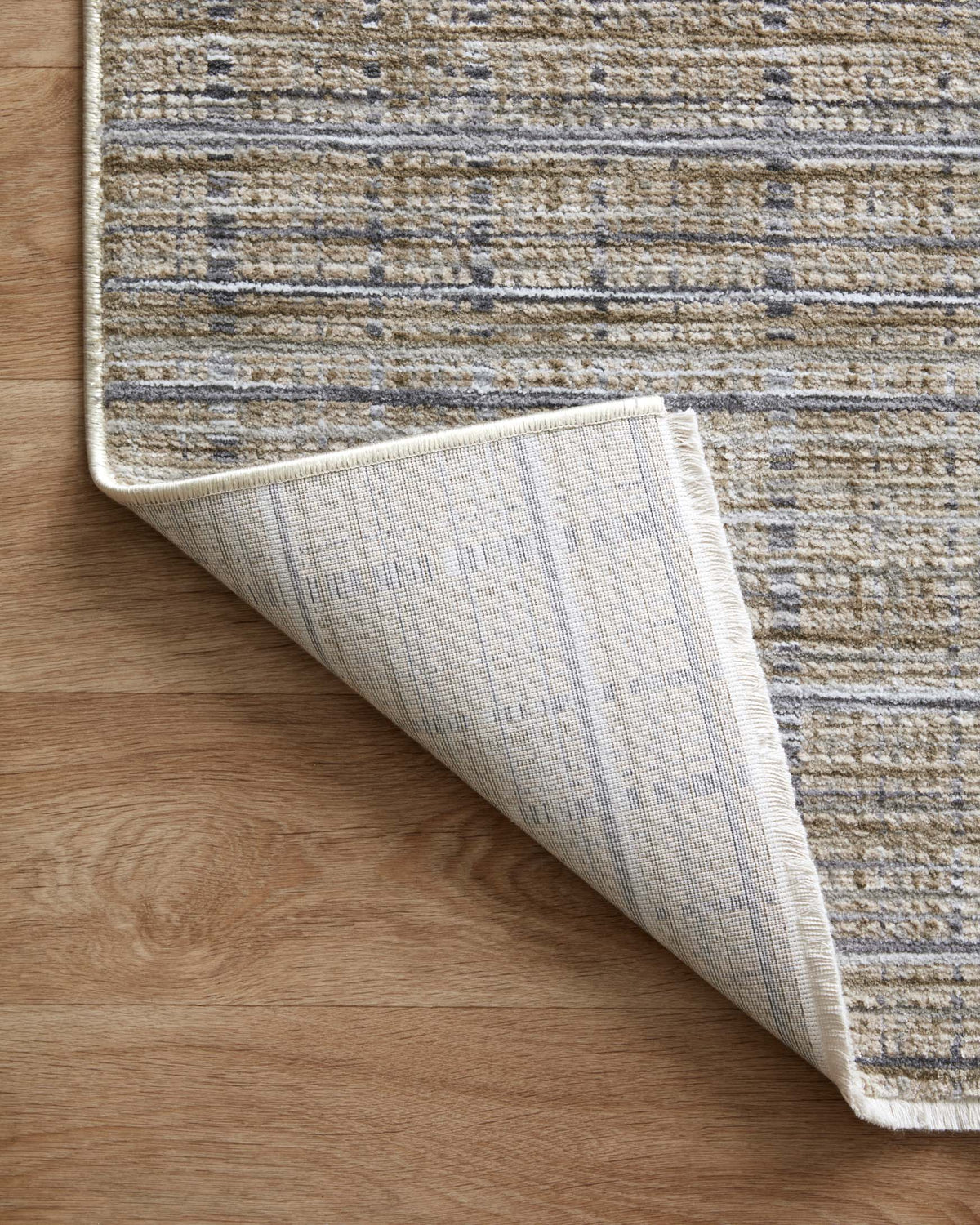 Reversed view of runner rug edge with light backing and beige-blue-gray texture