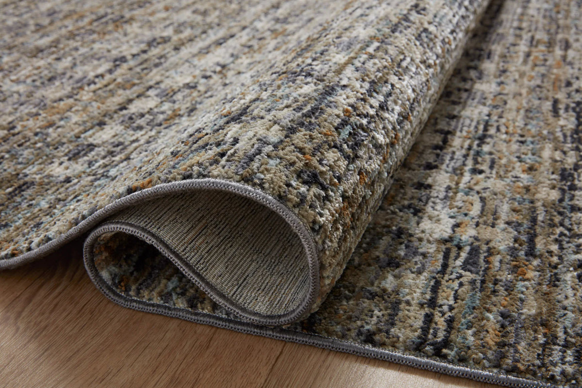 Close-up of charcoal and light gray rug edge with dark serged border