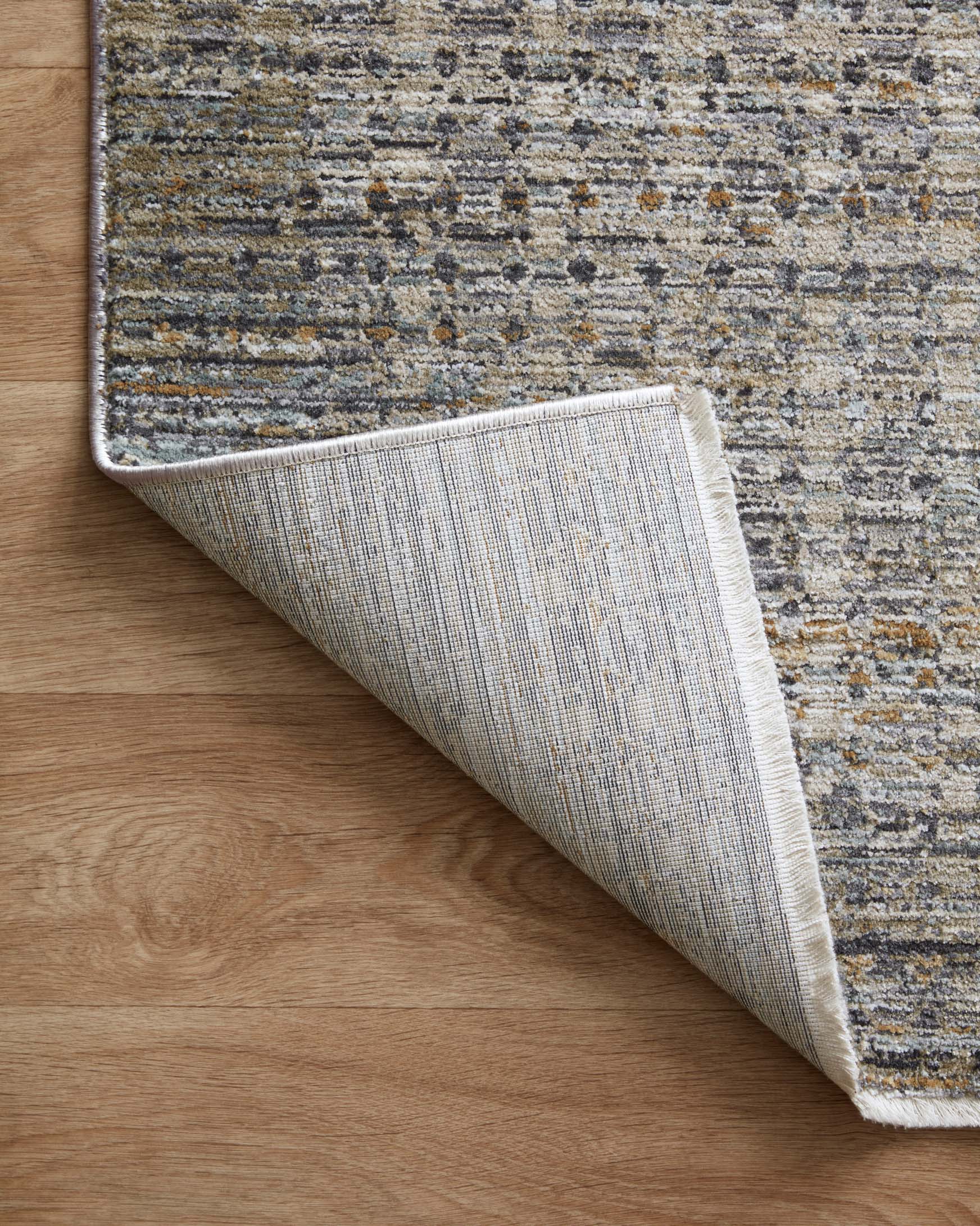 Reverse view of charcoal and gray runner rug showing backing and stitched edge