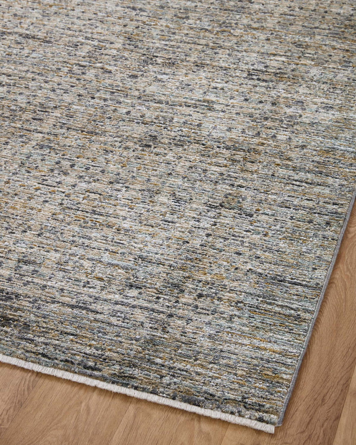 Charcoal and light gray woven area rug with speckled texture on hardwood floor.