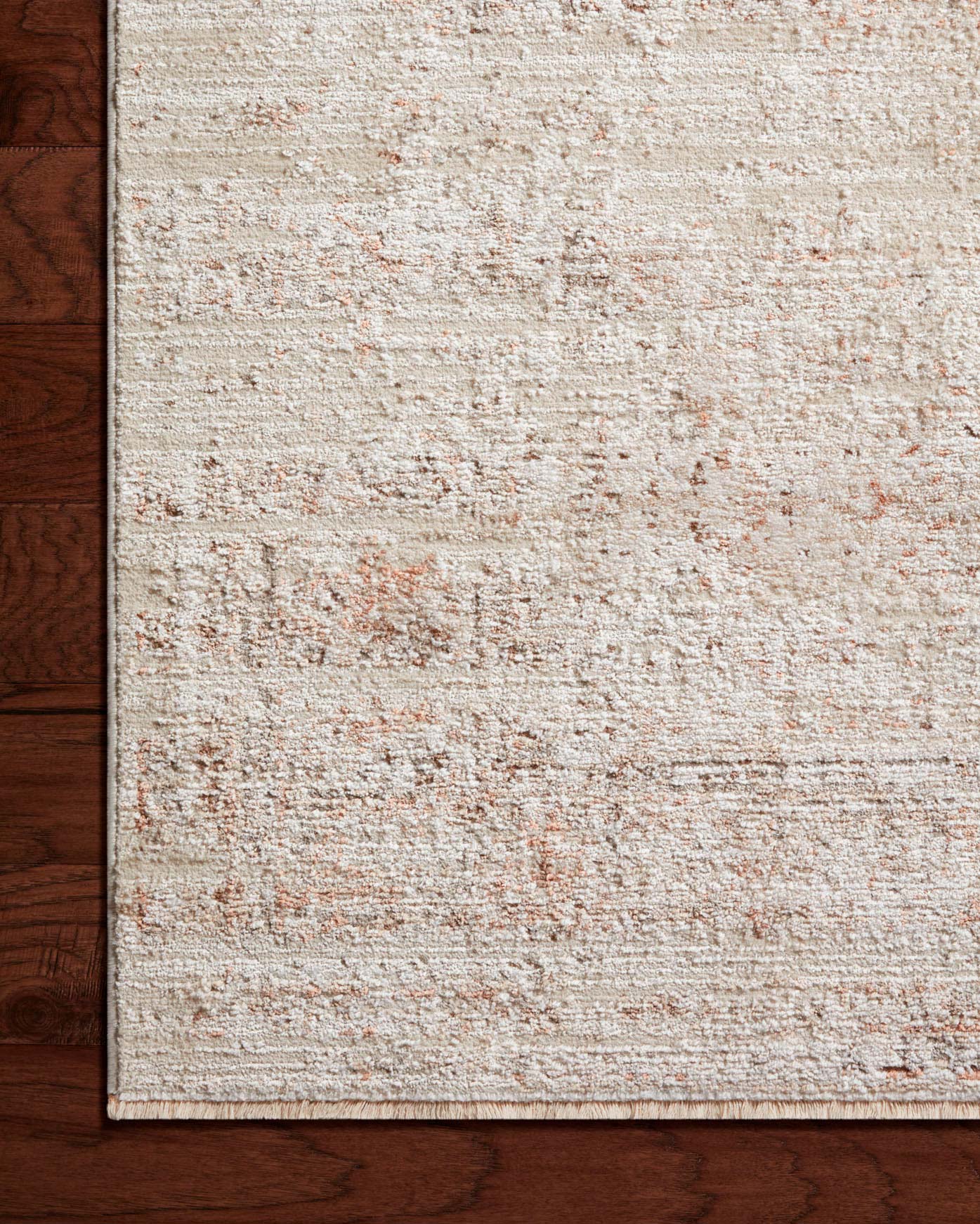 Beige runner rug corner with terracotta speckled distressed weave and flat border edge.