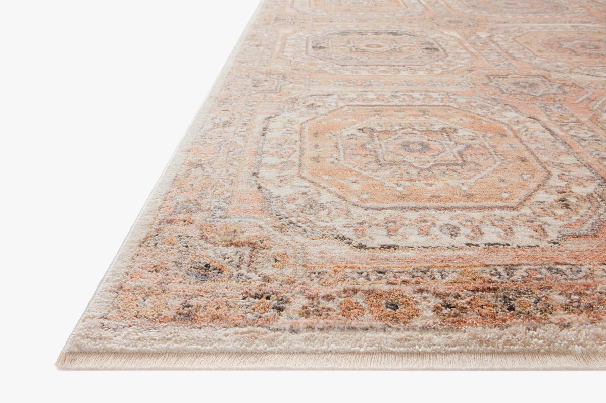 Apricot area rug with distressed medallion pattern and short fringed edge