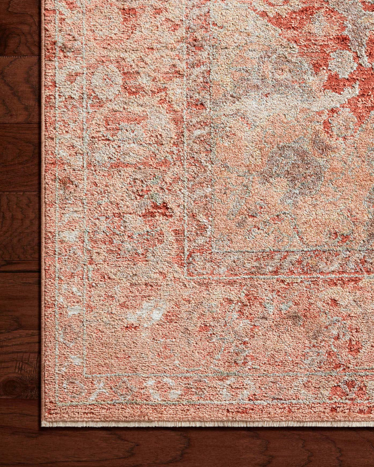 Spice area rug corner detail with faded coral, beige, and gray distressed pattern