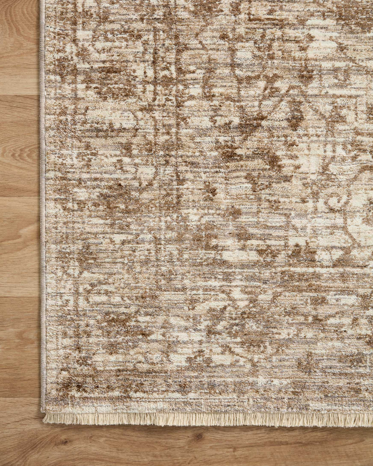 Traditional area rug corner with beige and brown distressed motif and fringe