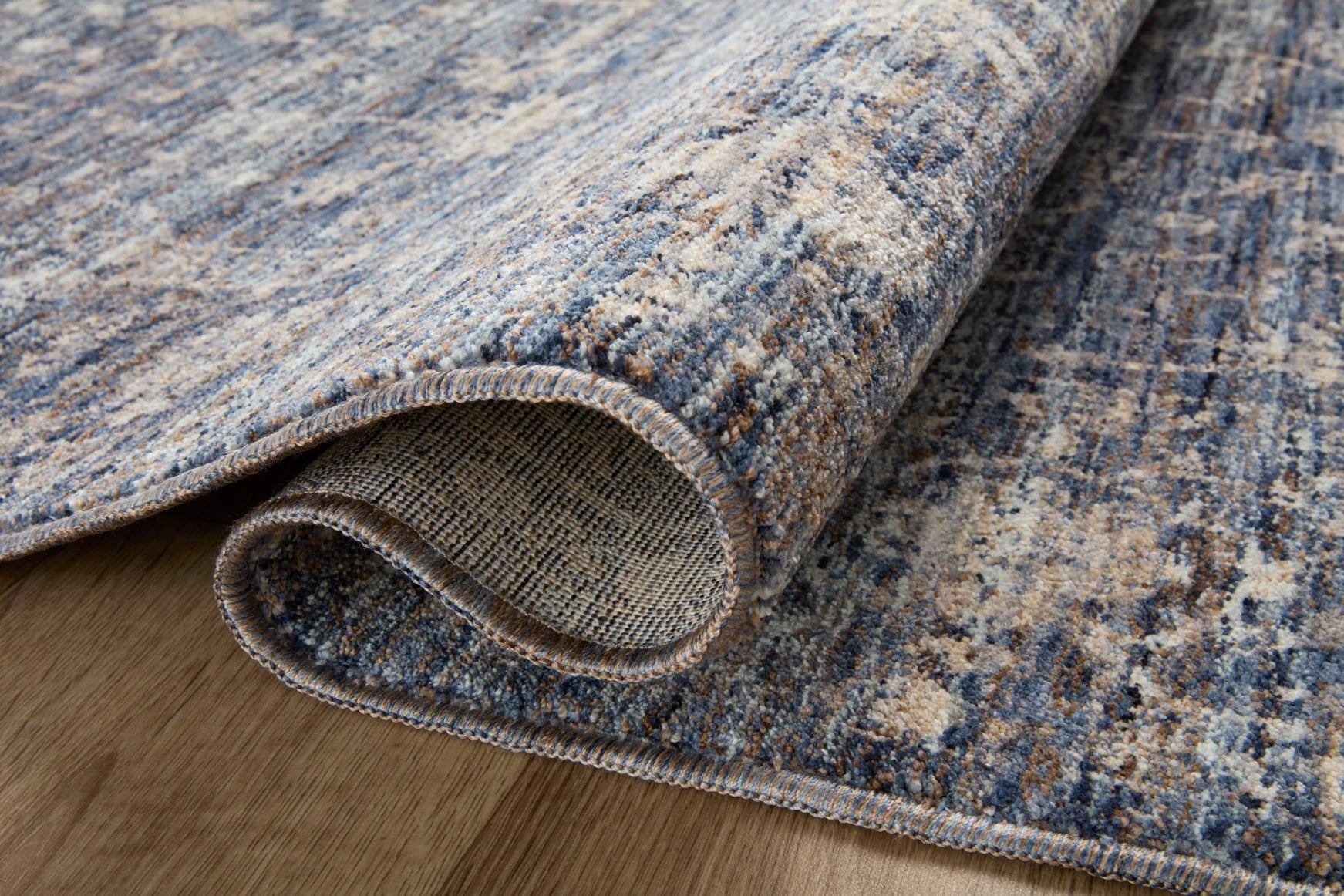 Blue and natural runner rug close-up, braided texture with fringed border