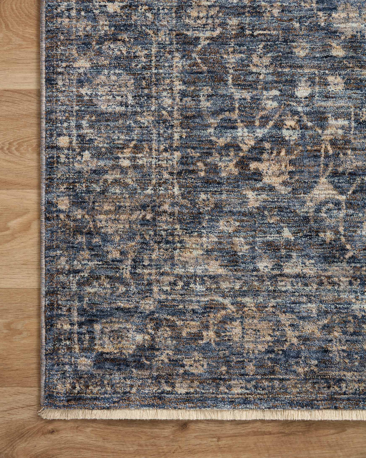 Blue and natural traditional rug corner with distressed motifs and bound edge